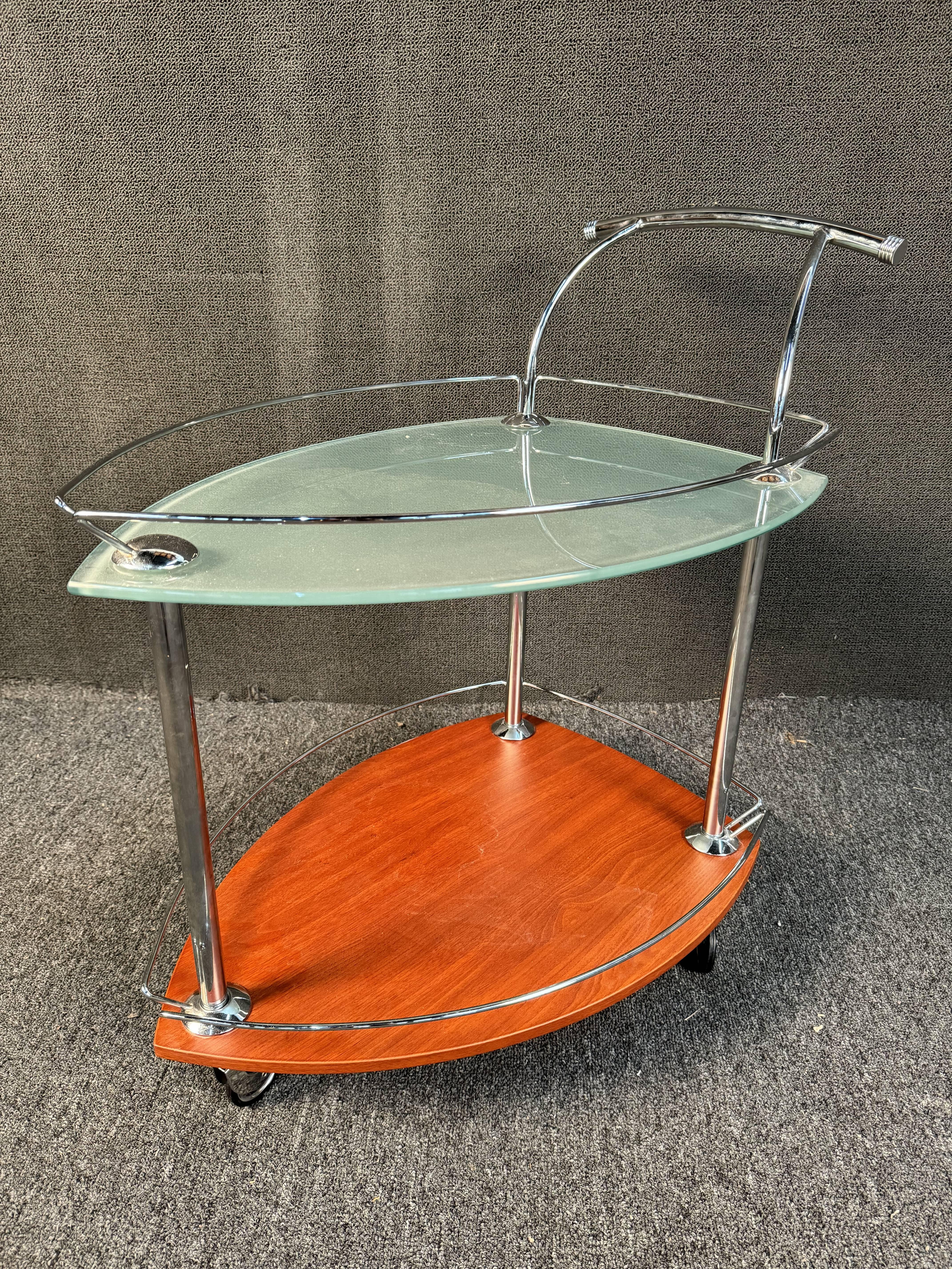 Unique triangular bar cart that features a tempered glass top, and wood bottom section. Perfect for entertaining your next cocktail party. Please contact dealer to confirm location (NY or NJ)

