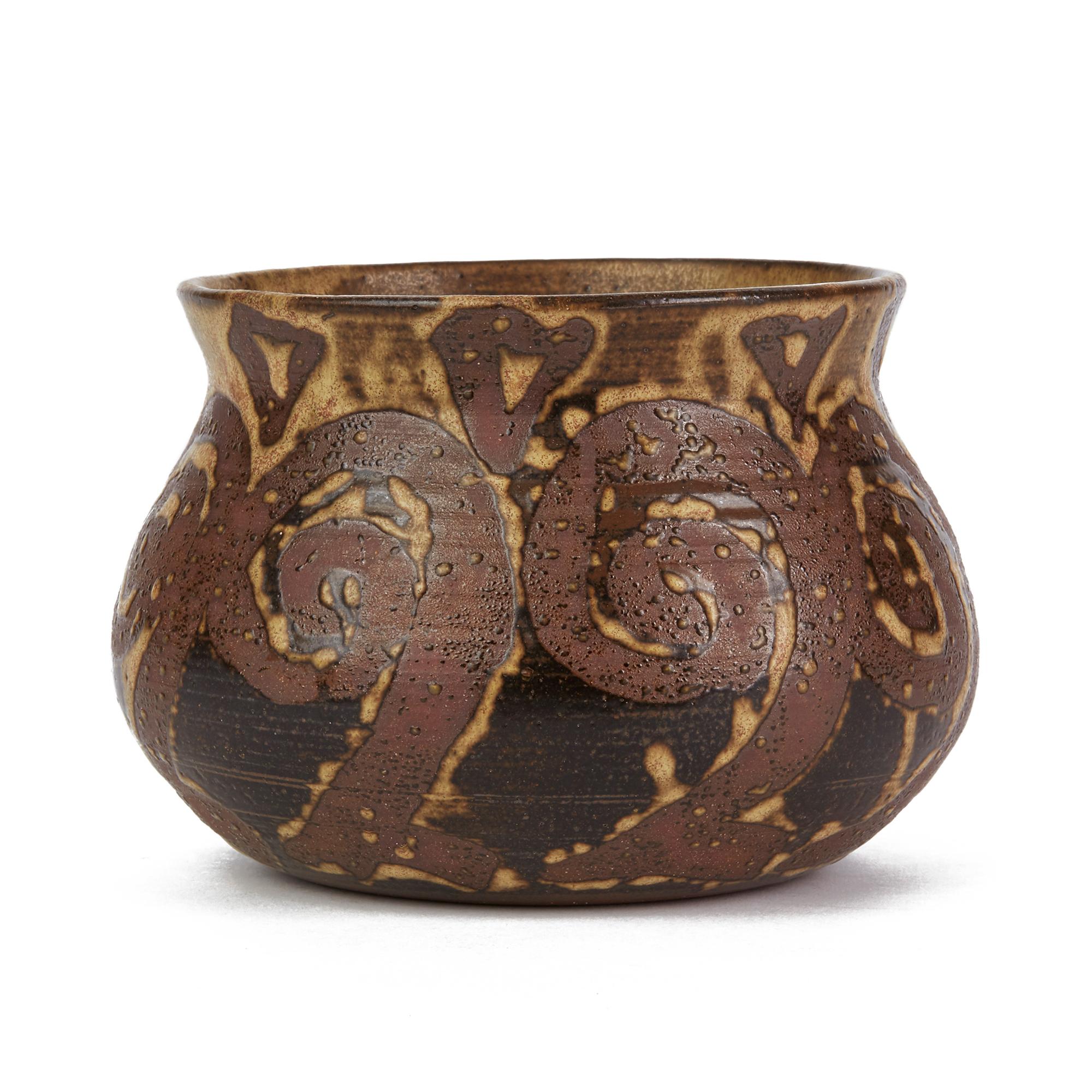 A very stylish and well made vintage studio pottery bowl with a tenmoku glazed swirl design around the body on a light mottled brown ground. The hand thrown bowl is finely made in red terracotta and has an impressed flower mark to the base. Offered
