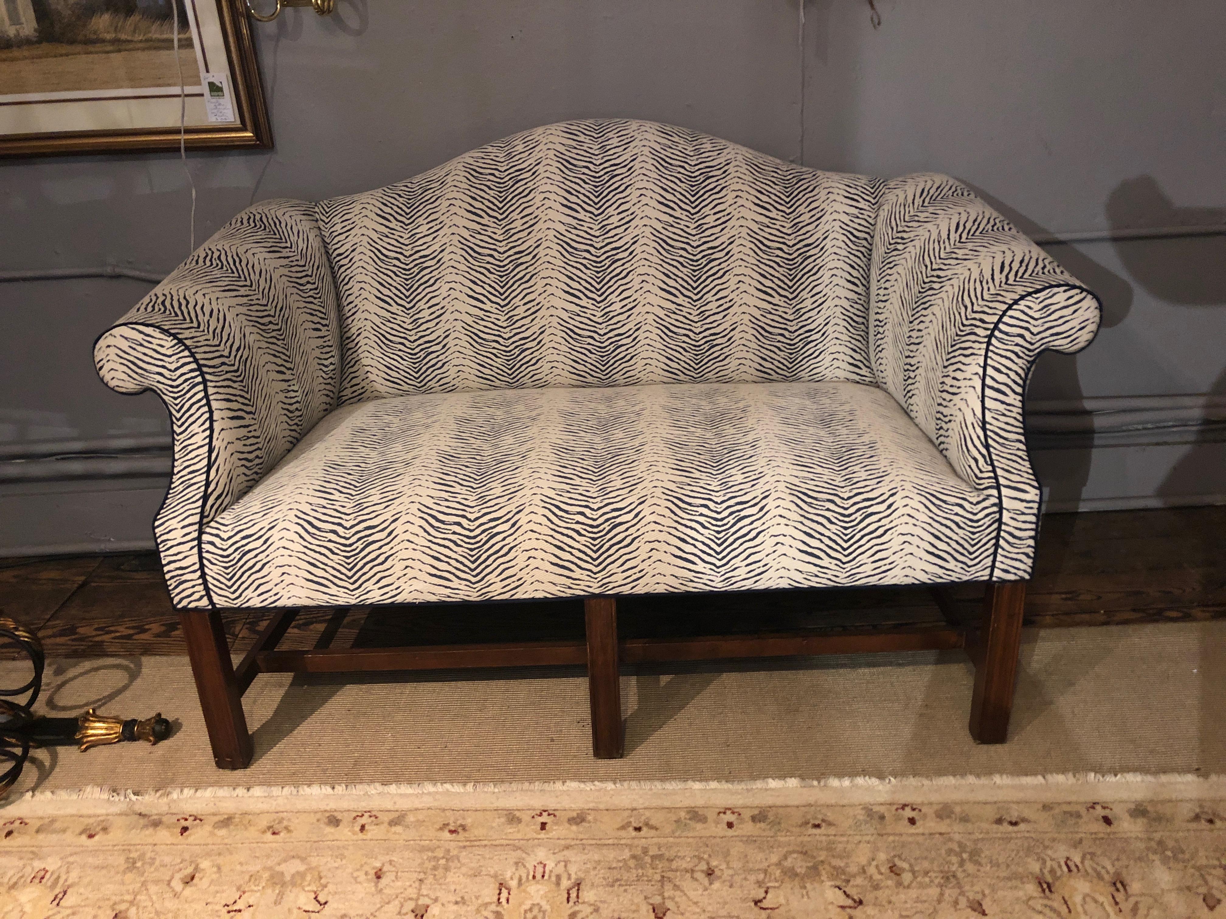 Well made, heavy and comfy loveseat having turned arms and camelback shape, with handsome mahogany legs. Upholstery is a dark blue and white faux animal print.
Measures: Seat height 18
Arm height 28.5.