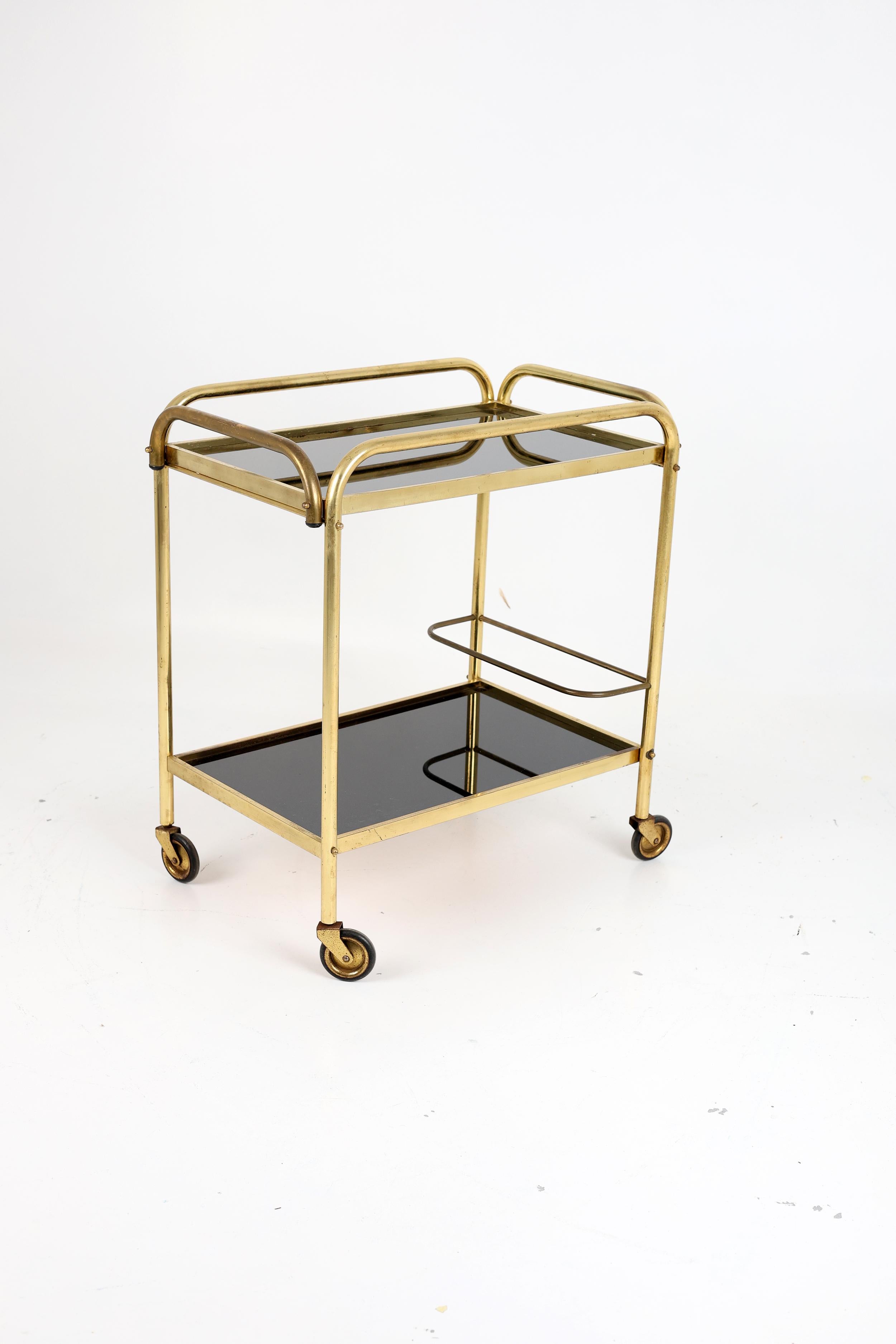 Stylish Vintage Brass and Black Glass Drinks Trolley with Removable Tray

A well-designed, well-crafted, and decorative drinks trolley that brings both function and flair to any interior. The combination of sleek black glass and polished brass gives