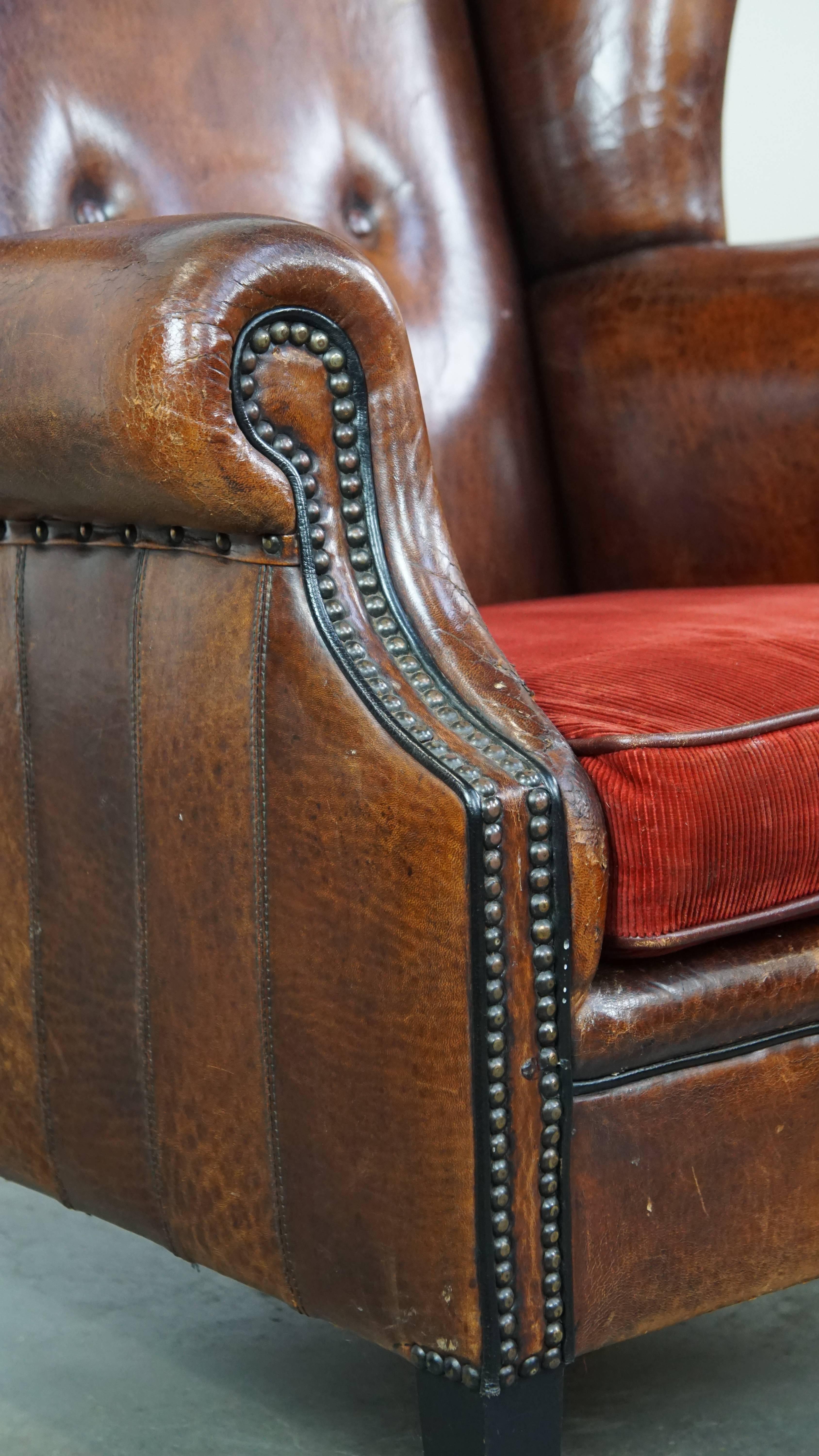 Stylish vintage, luxury sheepskin armchair with a red corduroy seat cushion For Sale 4