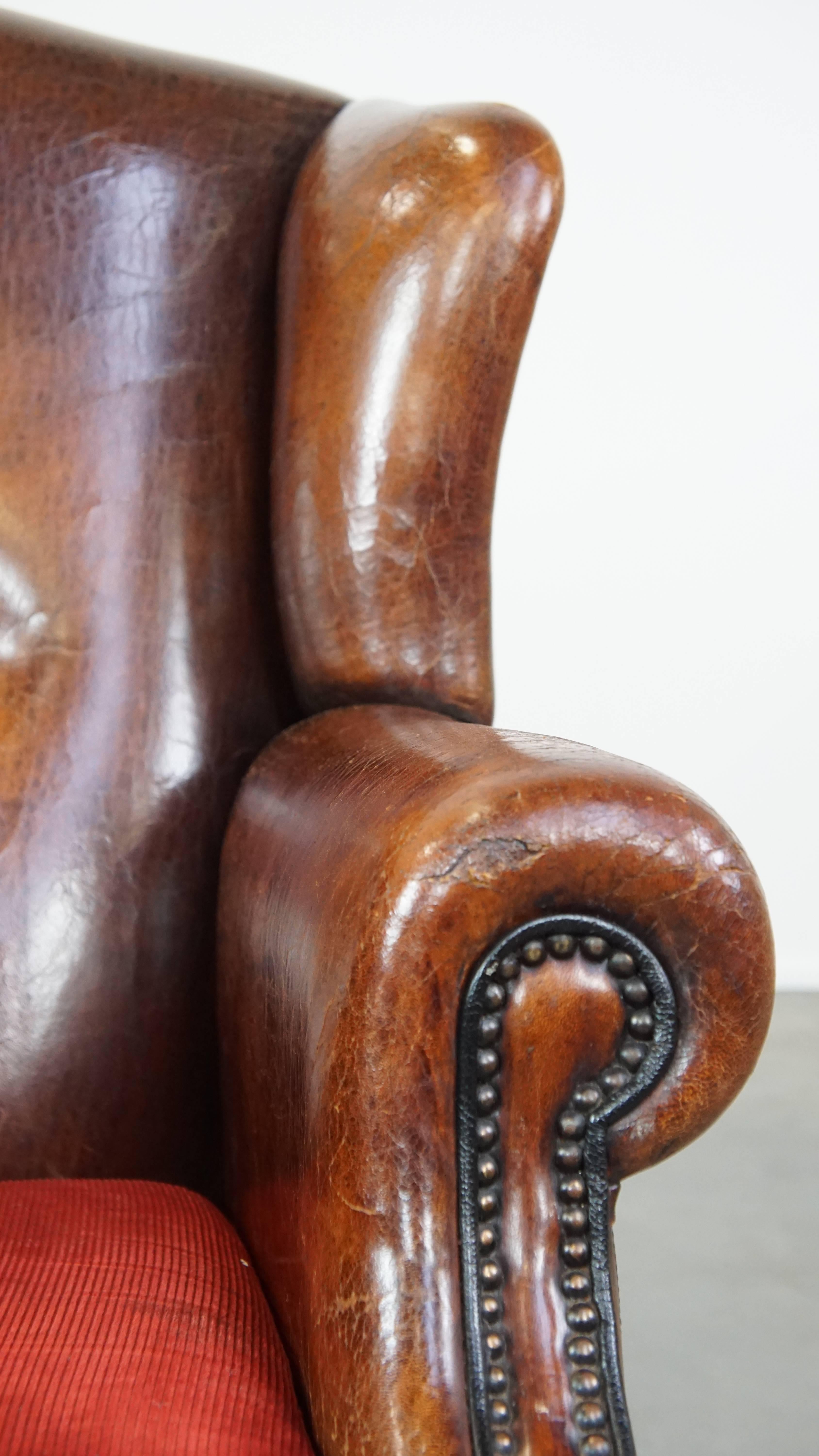 Stylish vintage, luxury sheepskin armchair with a red corduroy seat cushion For Sale 6