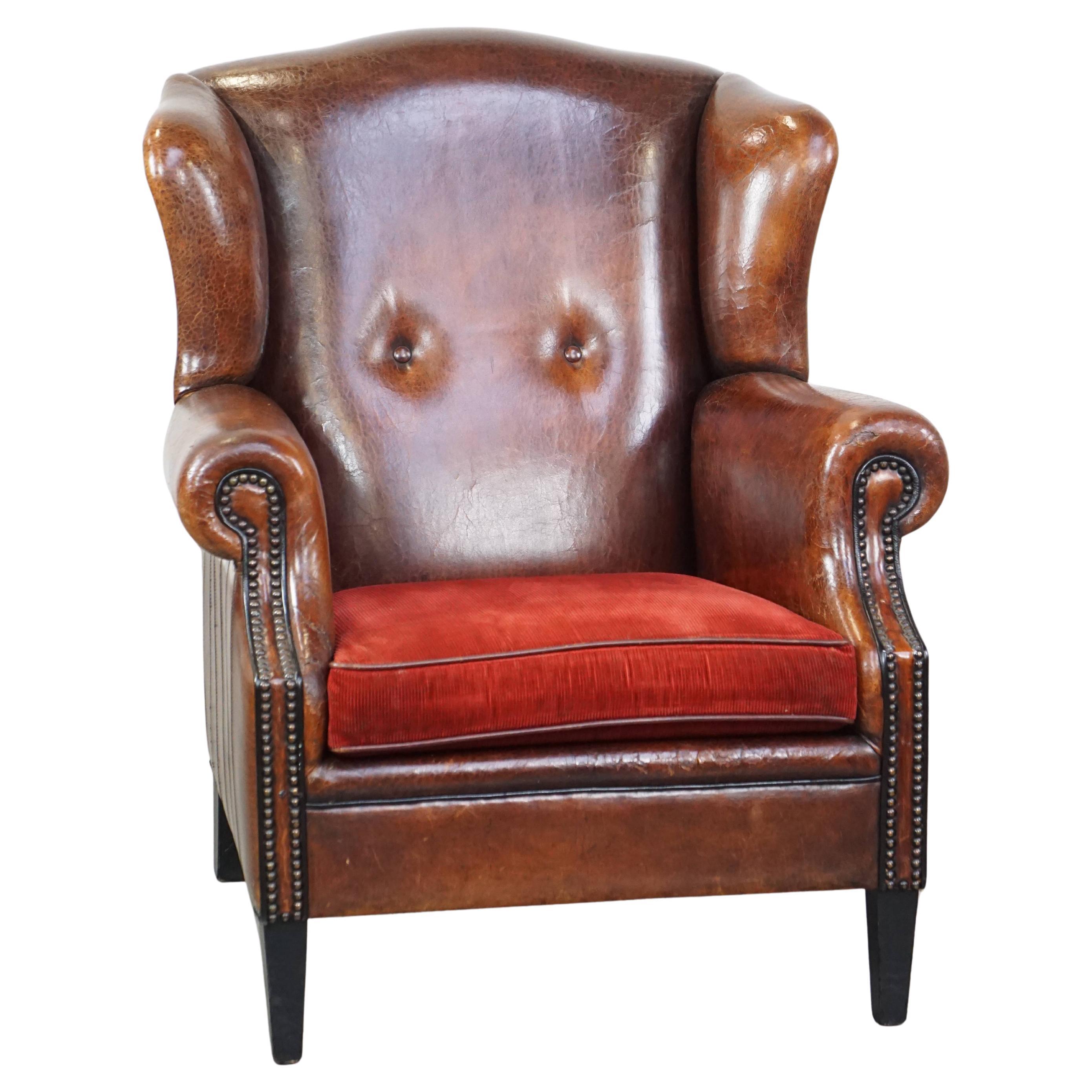 Stylish vintage, luxury sheepskin armchair with a red corduroy seat cushion For Sale