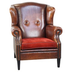 Stylish vintage, luxury sheepskin armchair with a red corduroy seat cushion
