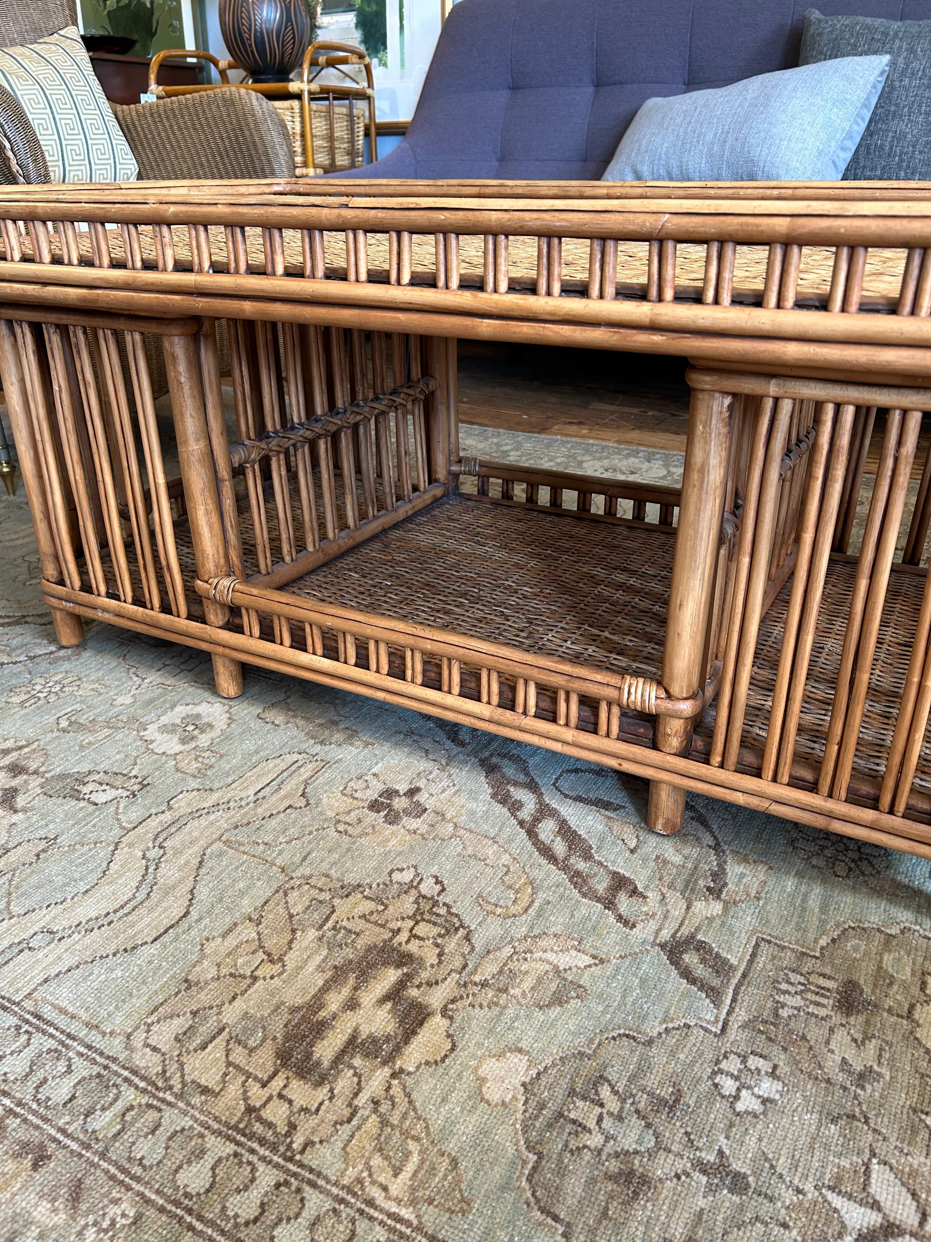 Table basse rectangulaire en rotin et osier tressé, élégante et moderne, avec galerie autour du plateau et section ouverte pour le rangement en dessous.
