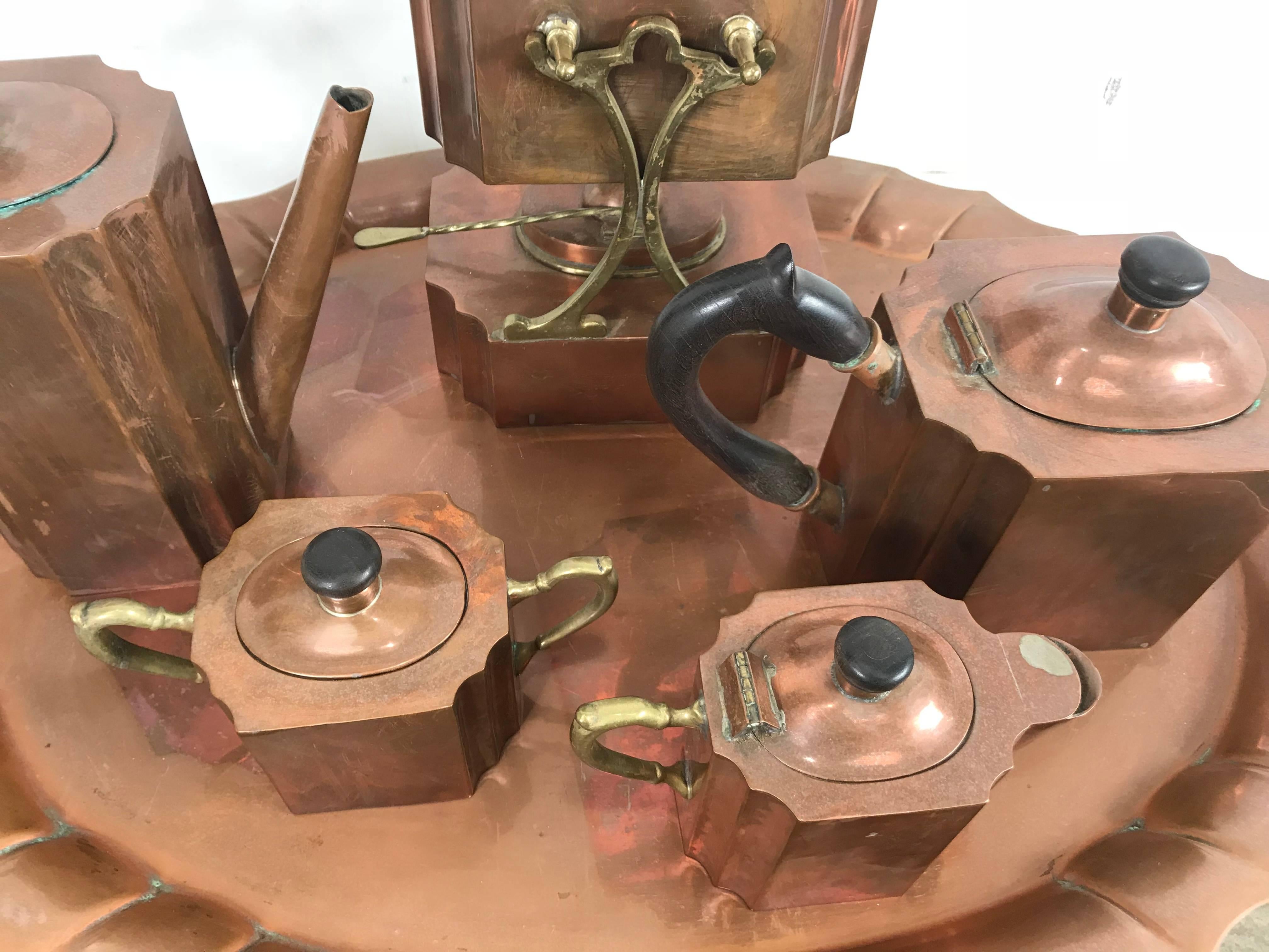 Stylized six-piece Art Deco copper tea and coffee set. Stunning design consisting of large tray, 31 x 18 pourer on stand with warmer 17 x 9, coffee pot, tea pot, creamer and sugar.