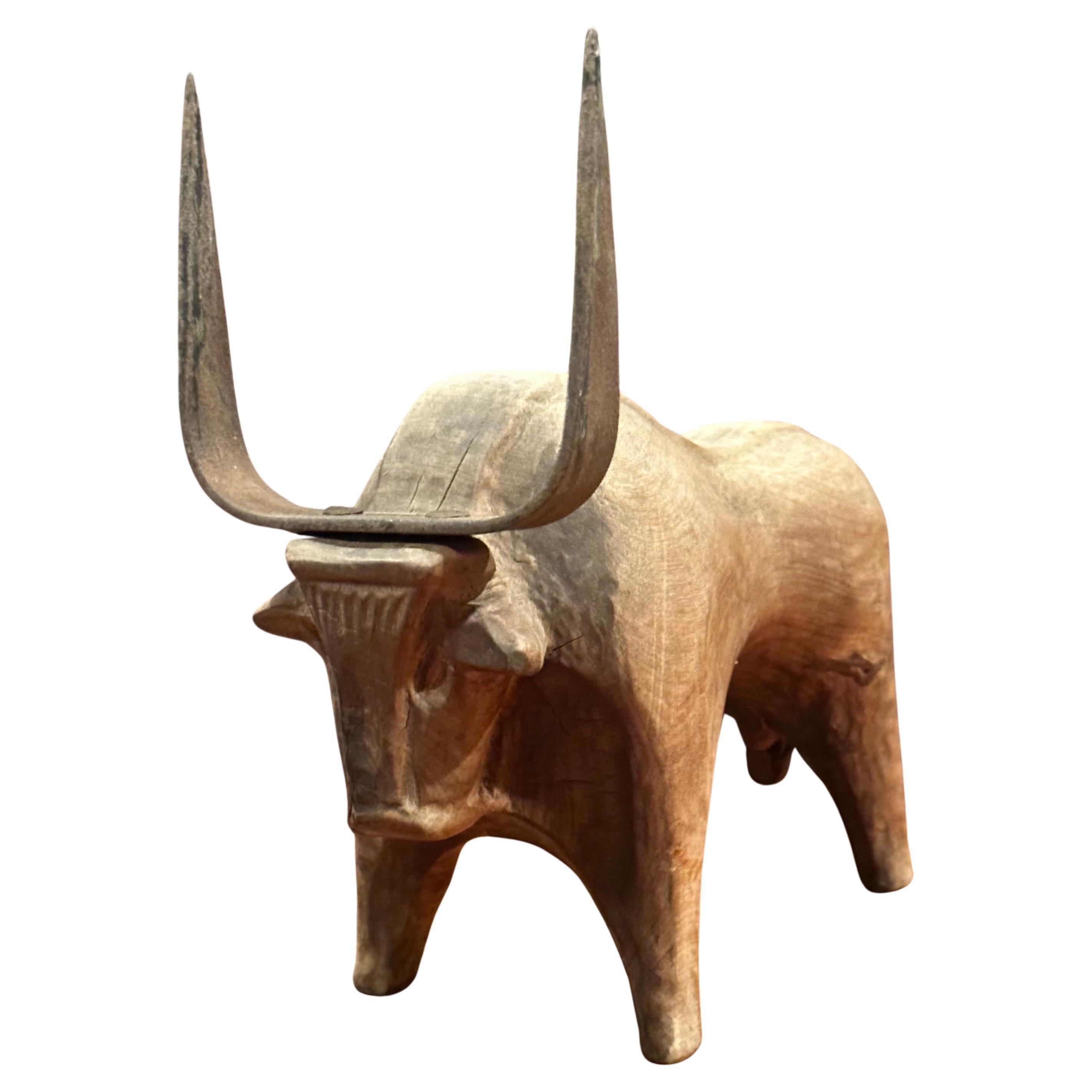 A very cool stylized carved wood and iron charging bull sculpture from Spain, circa 1970s. The piece is in good rustic condition and measures 4.5