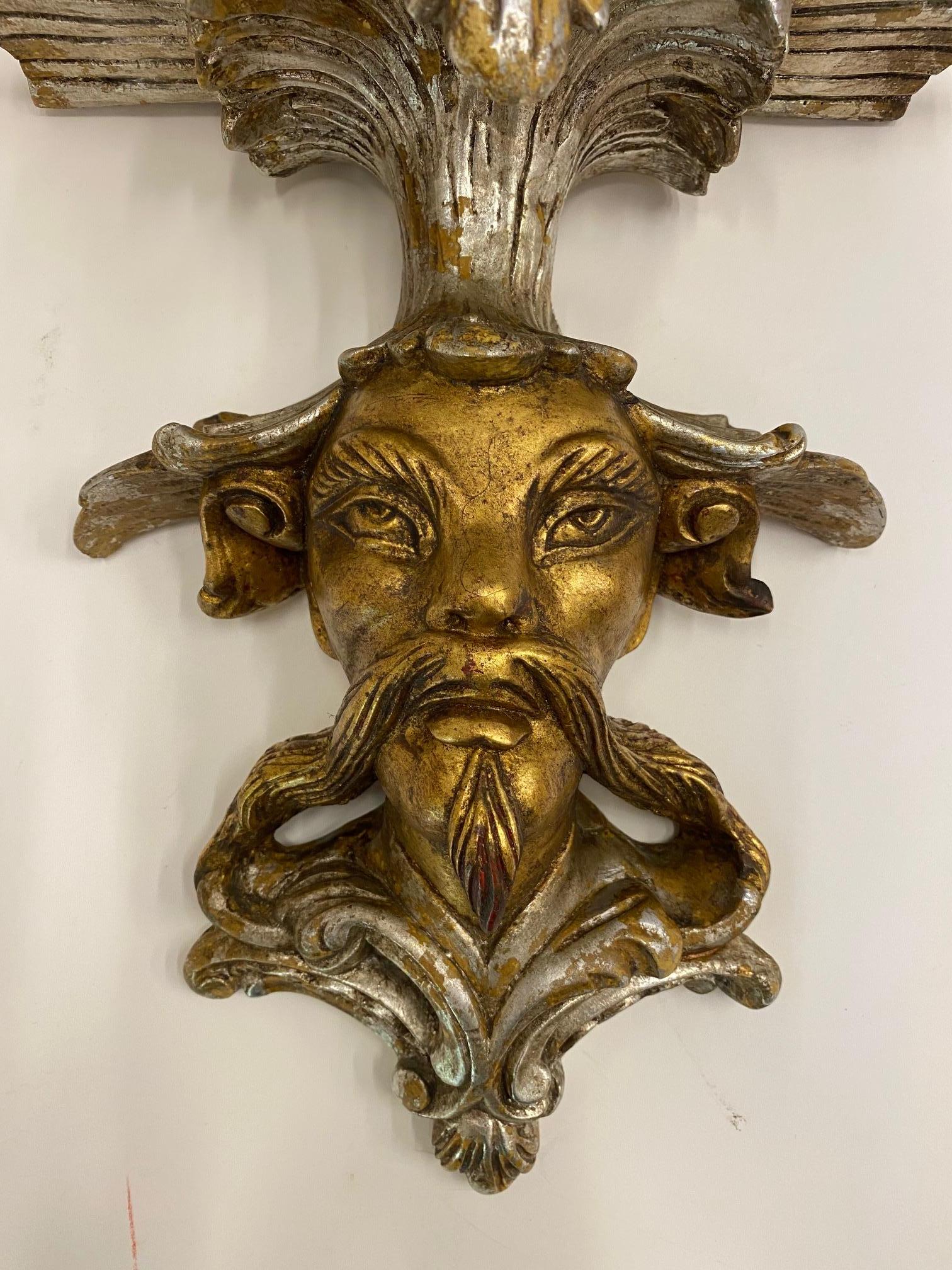 A stylized Asian male figural wall bracket having a wonderful long mustache and decorative hat that erupts into a platform for display.