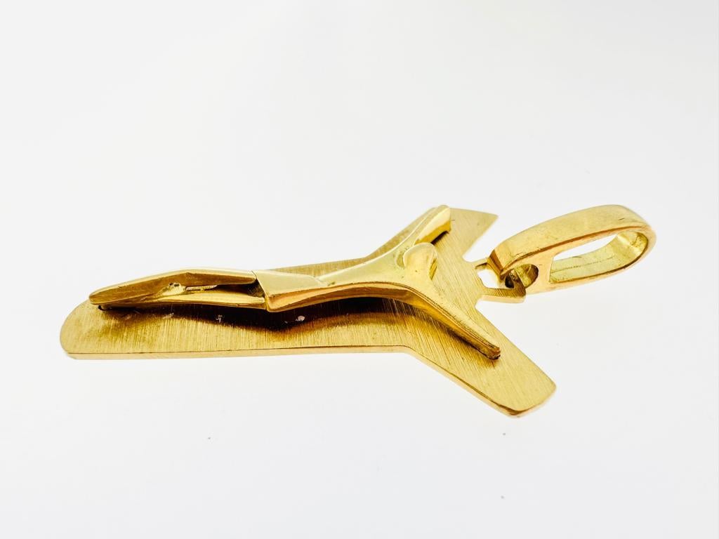 This Italian crucifix is worked with the satin finishing technique. Its very modern and stylized shape suits every occasion. The 18kt yellow gold crucifix is in good used condition, with normal signs of wear. The term crucifix refers to a cross with