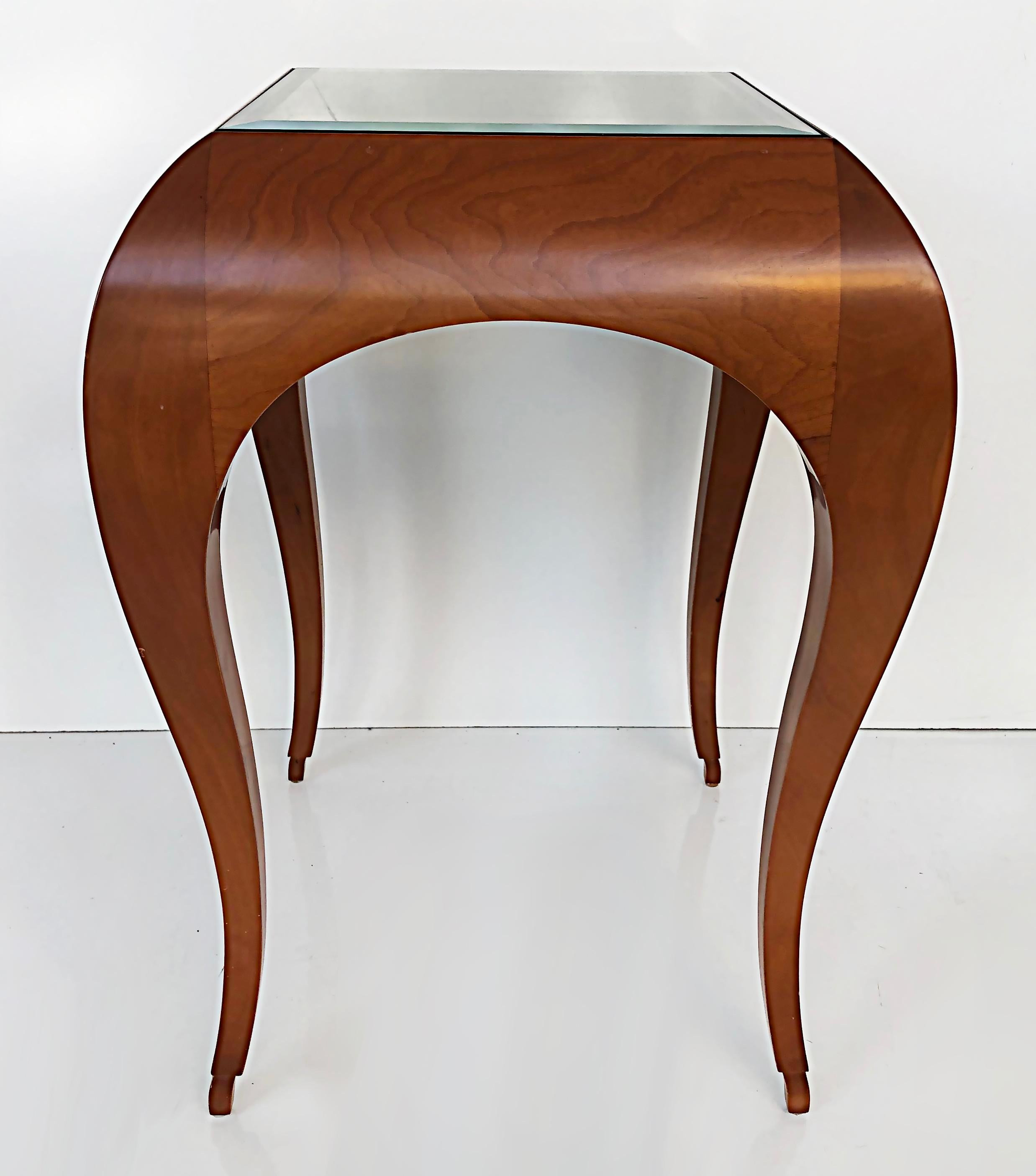 Stylized Curved Wood Side Tables, Manner of René Prou

Offered for sale is a pair of sinuously curved wood side tables with inset glass tops. These late 20th-century tables have been created in the manner of René Prou. The glass tops could be