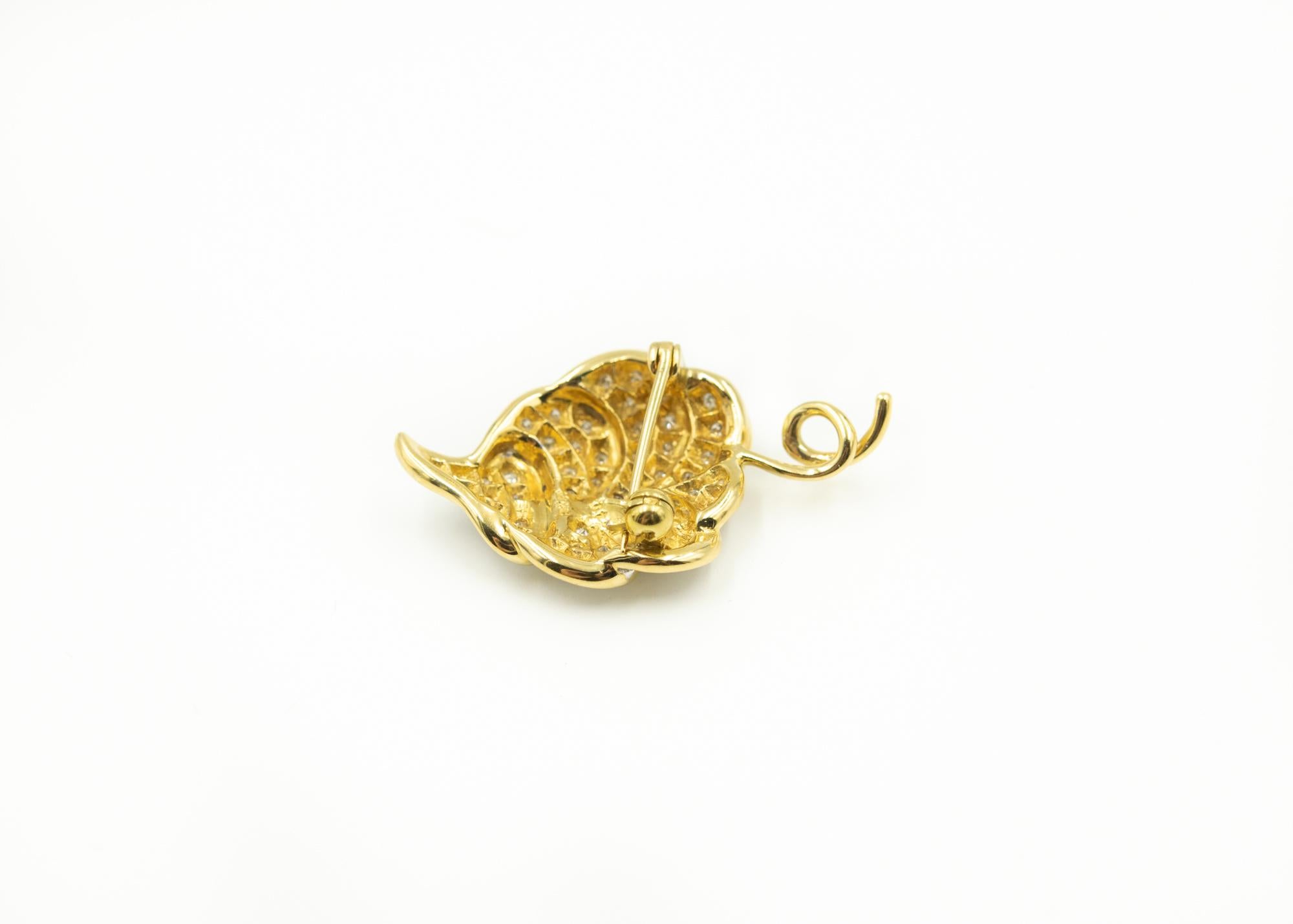 Beautiful three dimensional diamond white and yellow gold leaf brooch that canals be worked as a pendant.  The vine area has a loop that the chain can go through.  The leaf is accented by 56 stones with white gold background.  Loop is .11