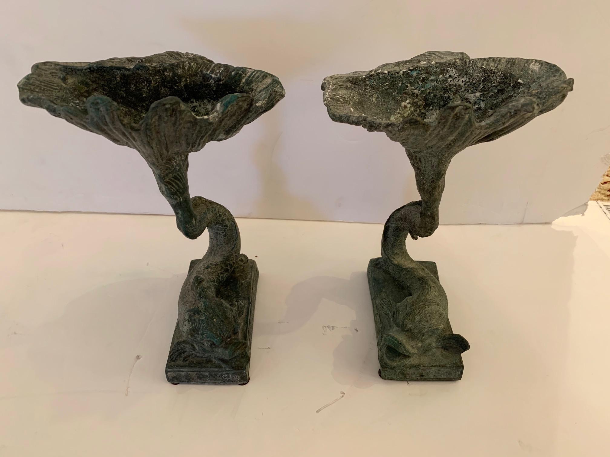 A pair of unusually expressionistic lead compotes having stylized elongated shape, earthy greenish black patina, and beautiful dolphin motif bases.