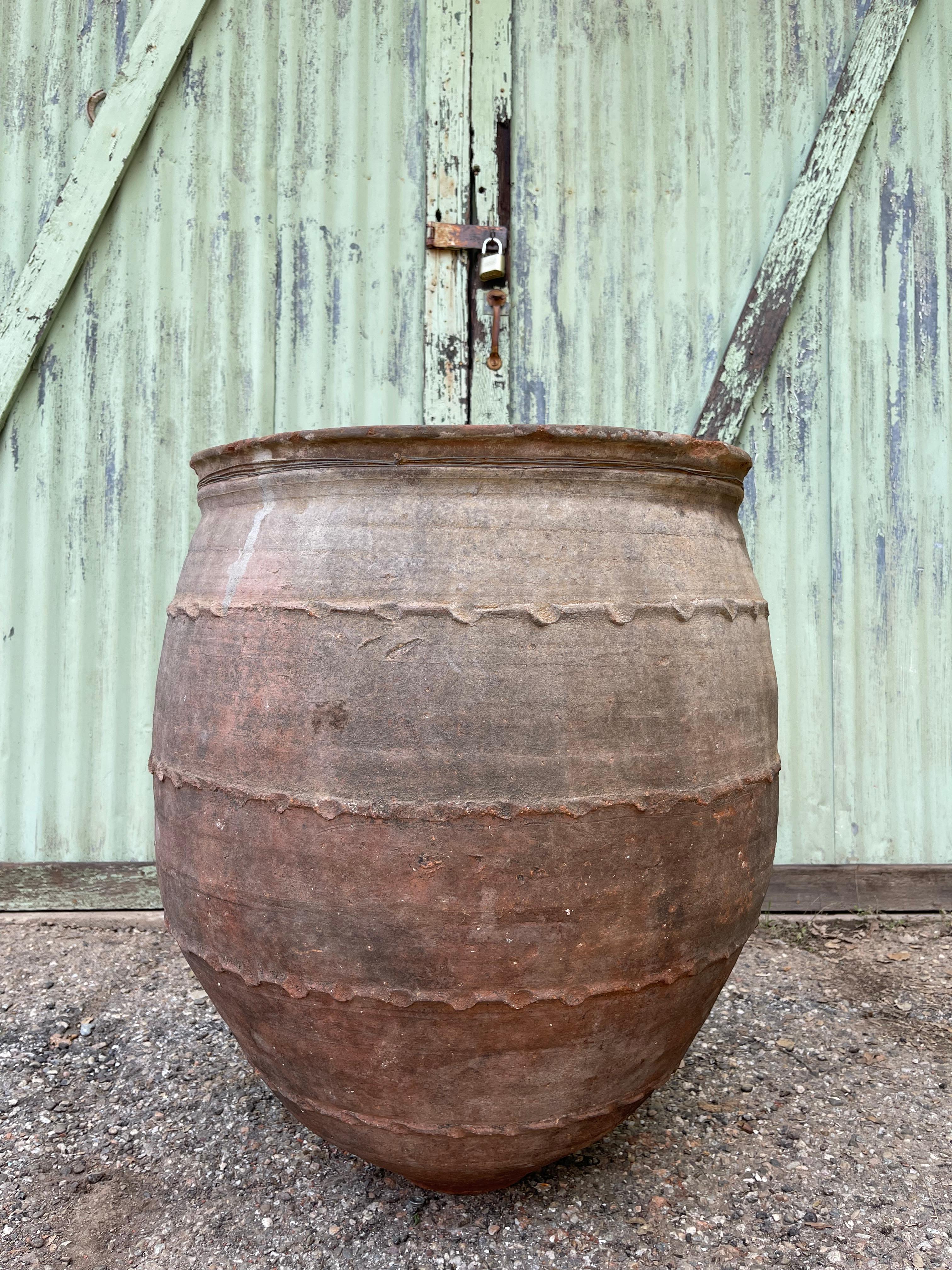 This large Turkish jug was used to store water in cisterns or carry it to sempozyum tables. The cylindrical body, tapered rim, and handles for carrying are common, functional design details on Anatolian water vessels. This unique piece features a