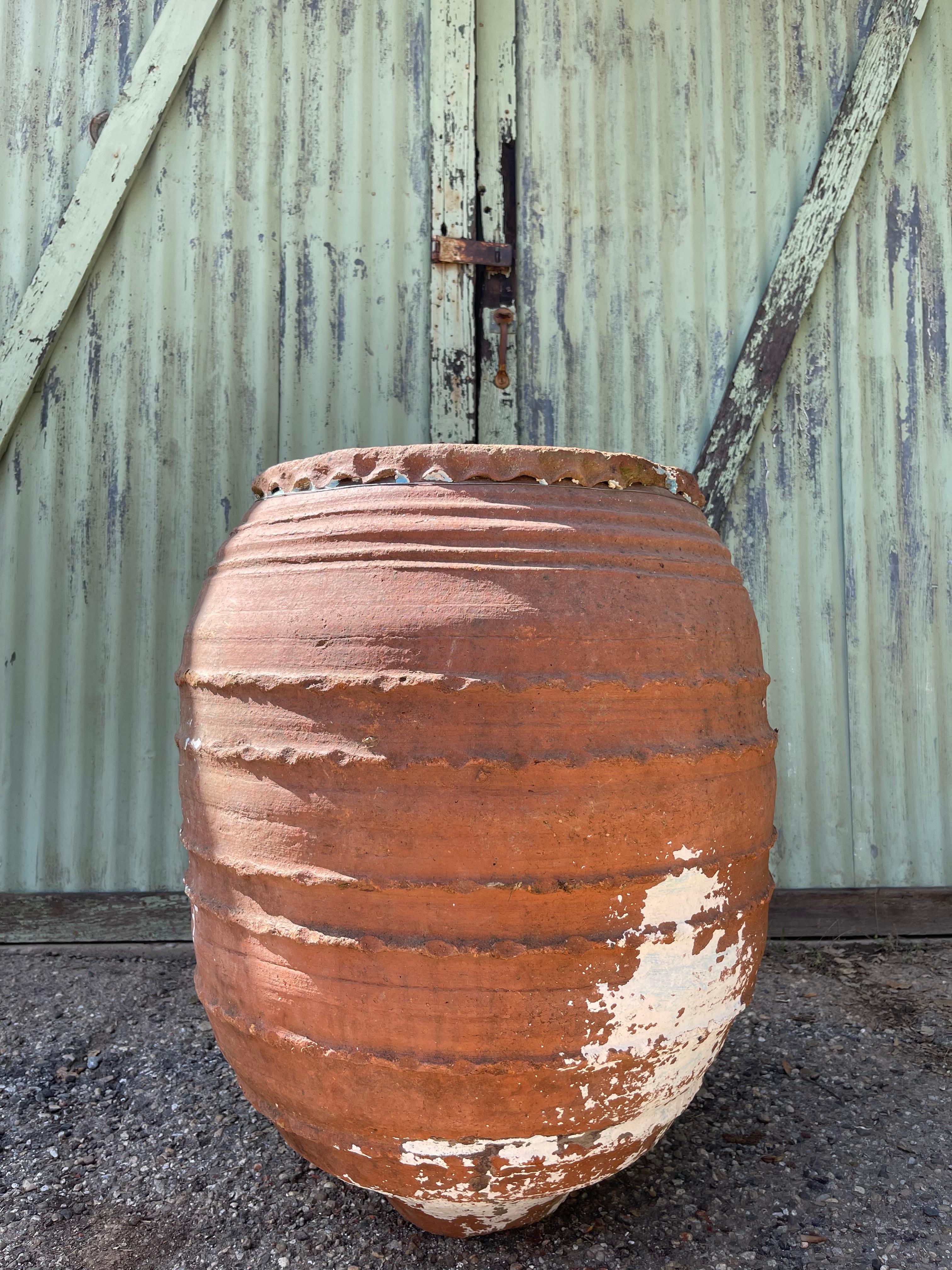 Questa grande brocca turca veniva utilizzata per conservare l'acqua nelle cisterne o per trasportarla ai tavoli del sempozyum. Il corpo cilindrico, il bordo affusolato e le maniglie per il trasporto sono dettagli di design comuni e funzionali dei