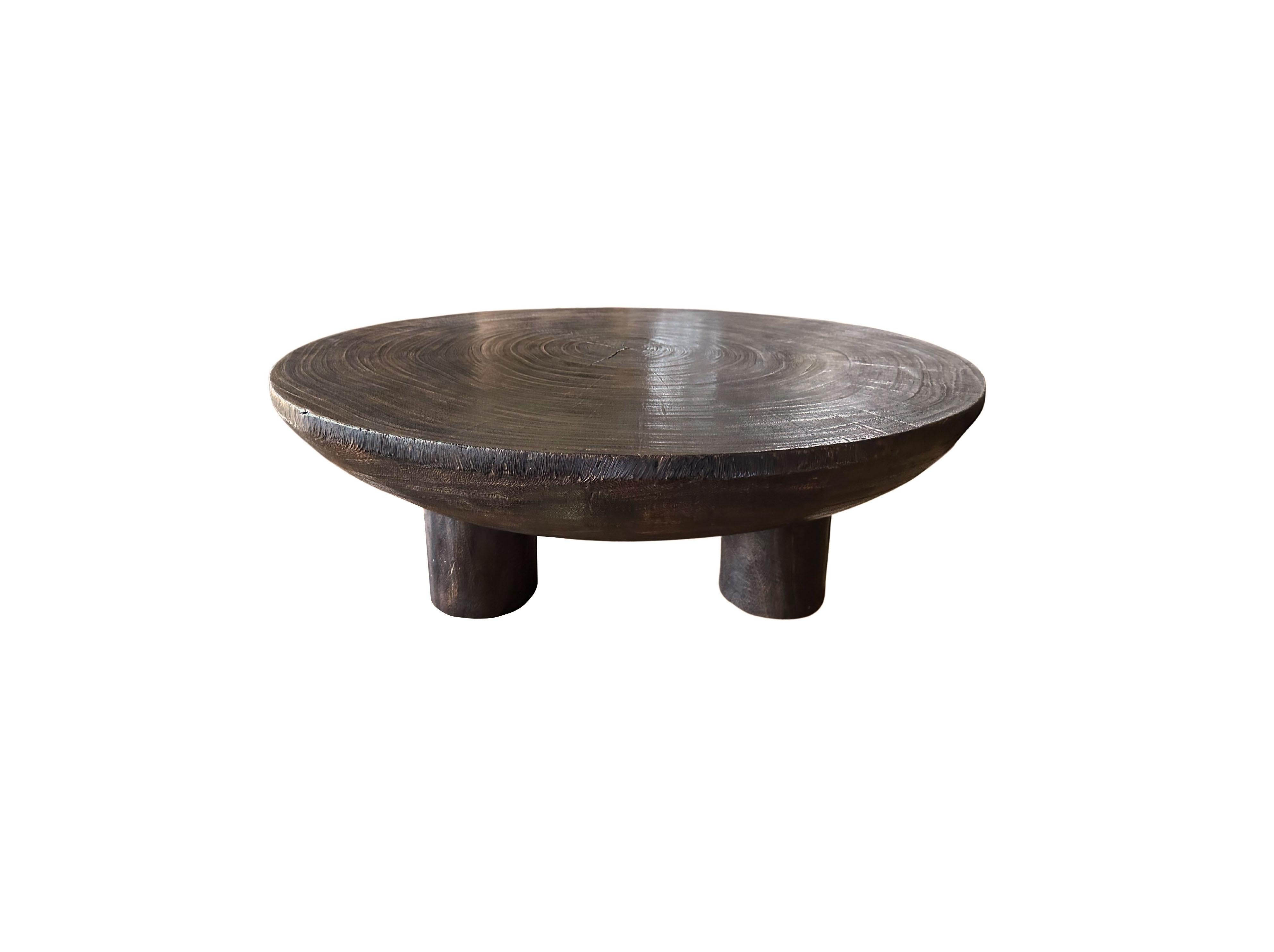 A wonderfully sculptural round table crafted from suar wood. To achieve its pigment the wood was burnt numerous times and then finished with a clear coat. The mix of wood textures and shades adds to its charm. The 