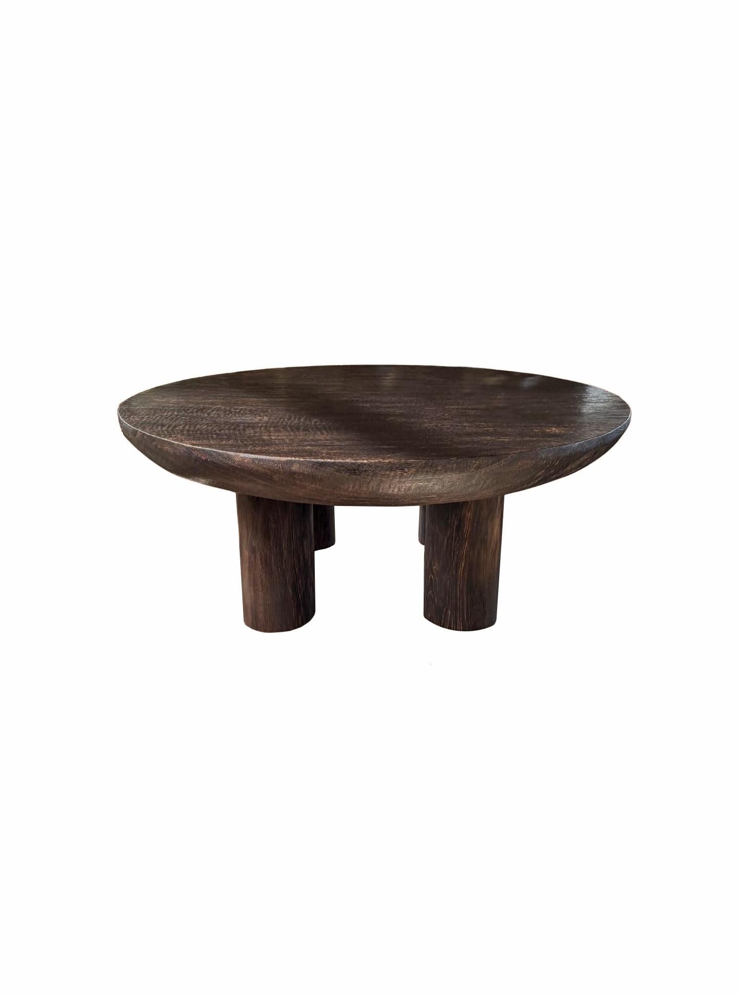 Crafted with timeless sophistication, this round table showcases the natural beauty and richness of solid suar wood. Its gracefully sculpted silhouette features a stunning tabletop with organic, flowing curves that highlight the unique grain
