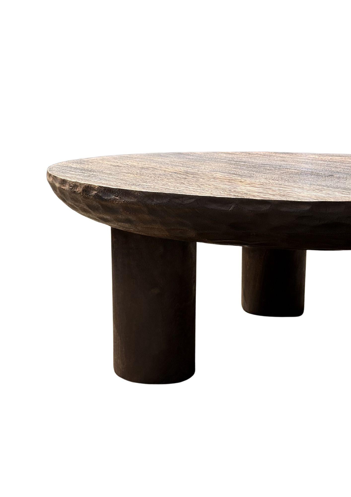 Une table ronde merveilleusement sculpturale fabriquée en bois de suar. Pour obtenir son pigment, le bois a été brûlé à de nombreuses reprises, avant d'être recouvert d'une couche transparente. Le mélange de textures et de teintes de bois ajoute à