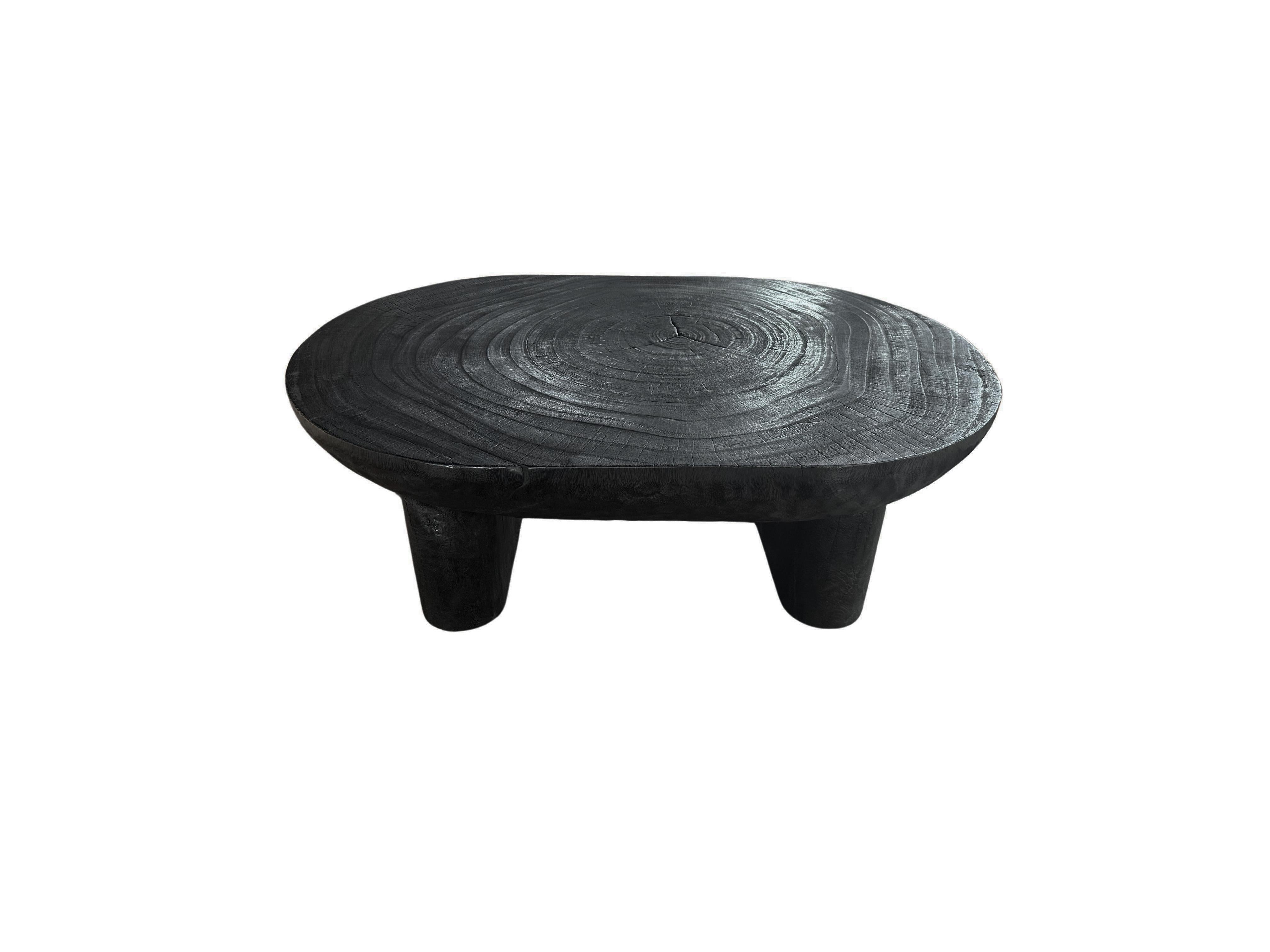 Una mesa maravillosamente escultural fabricada en madera de suar. Para conseguir su pigmento, la madera se quemó numerosas veces y luego se terminó con una capa transparente. La mezcla de texturas y tonos de madera le añade encanto. El tablero de la