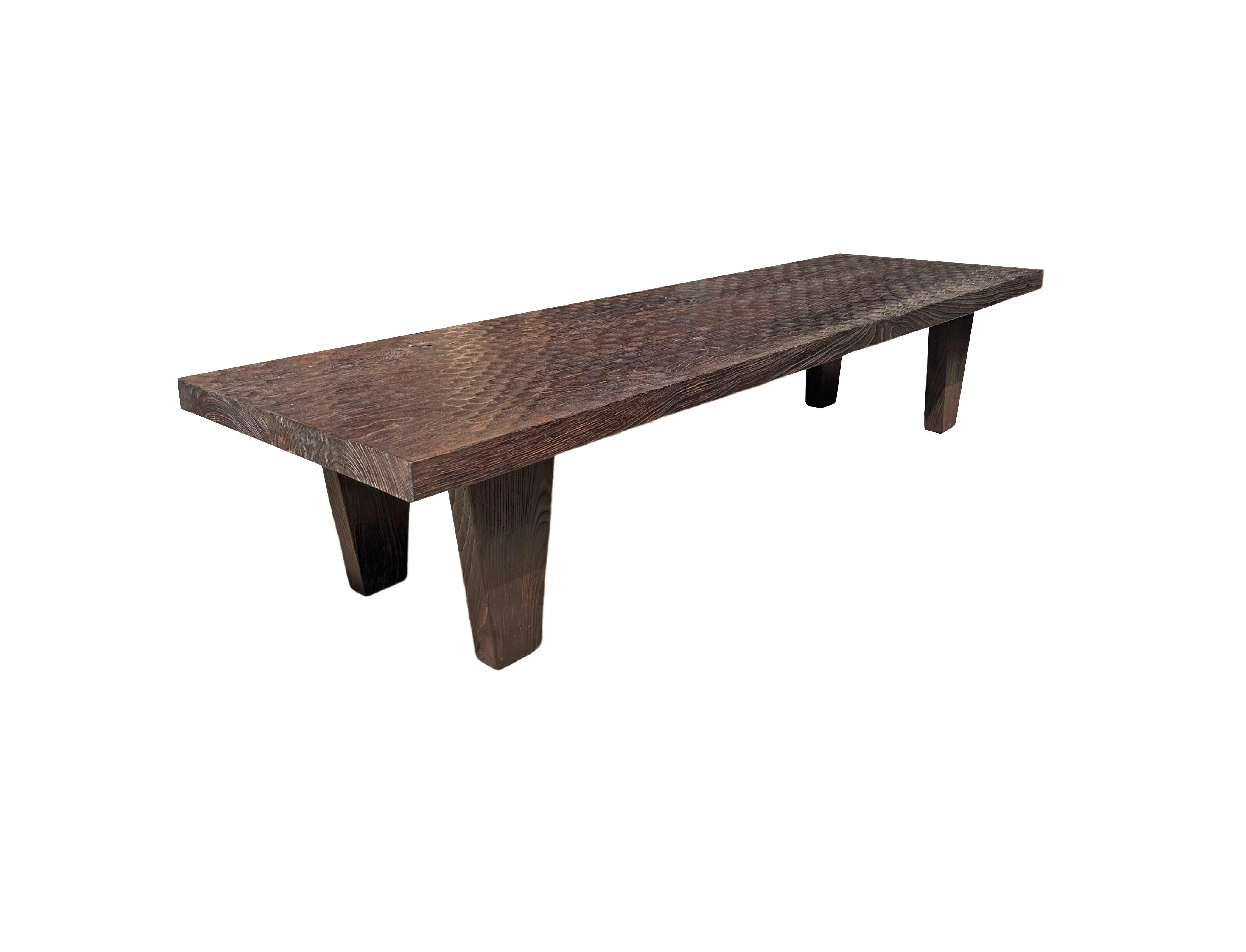 A wonderfully sculptural table crafted from suar wood. To achieve its pigment the wood was burnt numerous times and then finished with a clear coat. The mix of wood textures and shades adds to its charm. The table top was crafted from a single slab