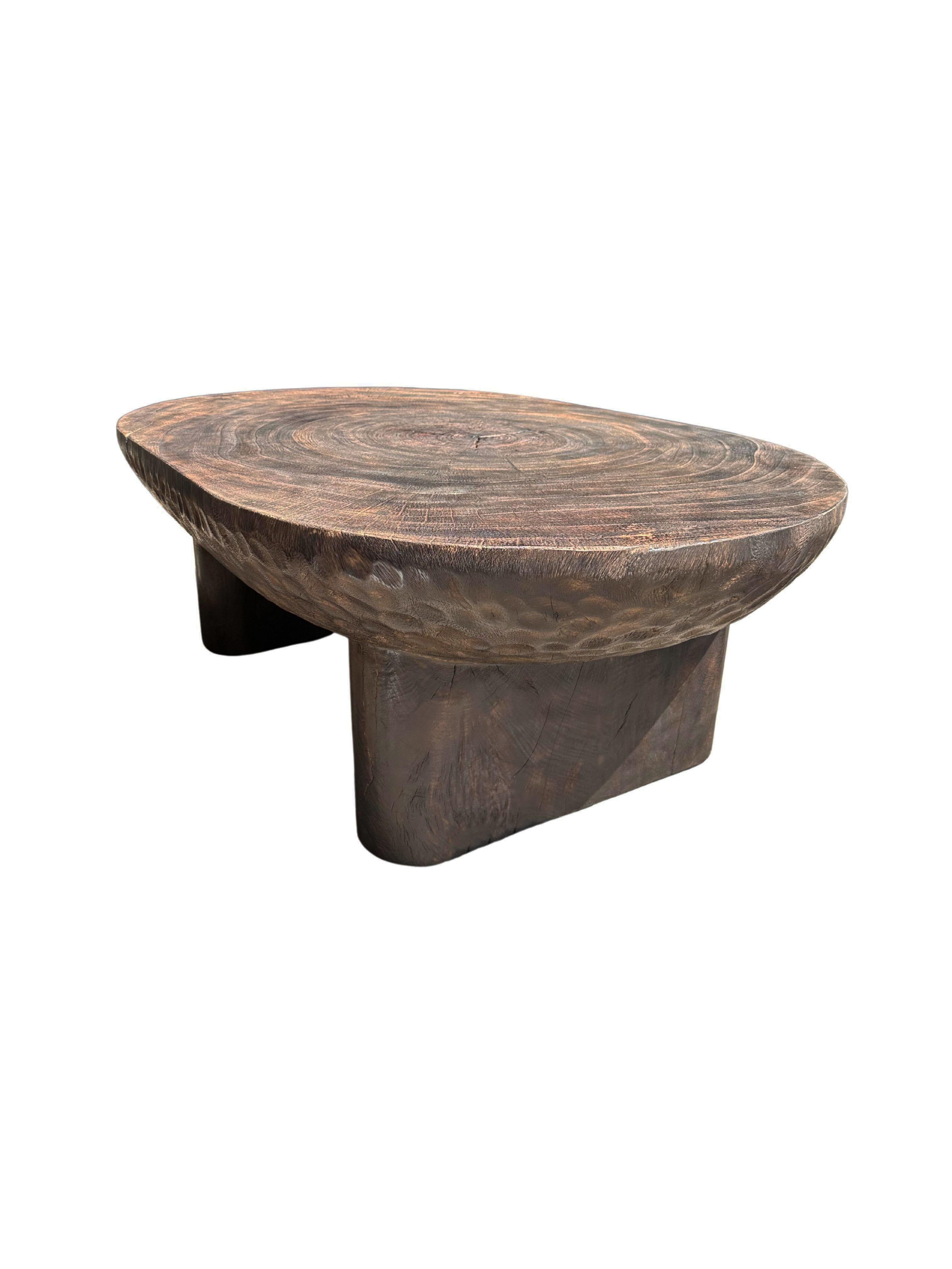 A wonderfully sculptural table crafted from suar wood. To achieve its pigment the wood was burnt numerous times and then finished with a clear coat. The mix of wood textures and shades adds to its charm. The table top was crafted from a single slab