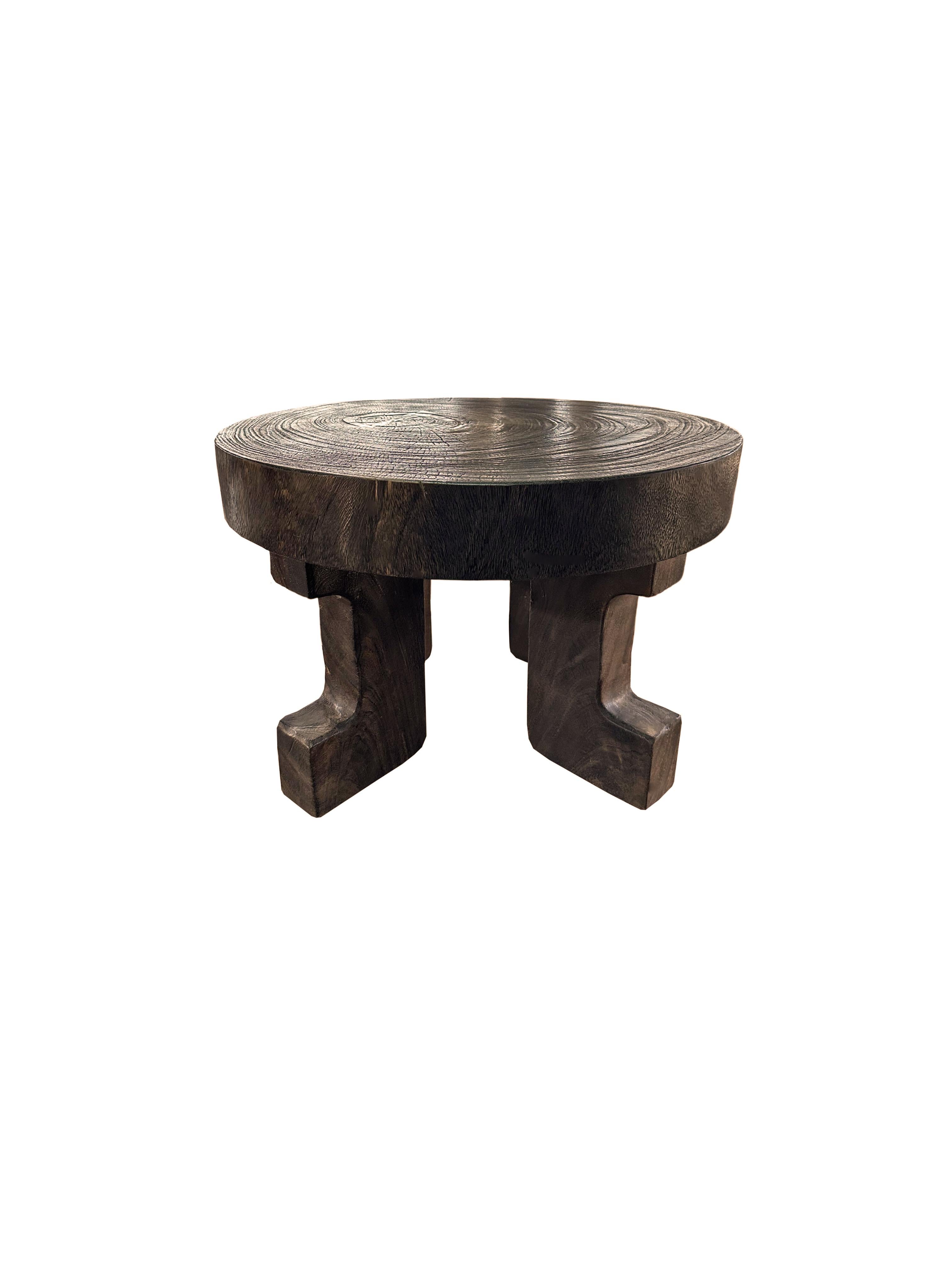 Voici une étonnante table basse ronde en bois de manguier, un mélange parfait d'art et de beauté naturelle. Cette table présente des pieds sculptés de manière complexe qui ajoutent une touche de sophistication et de charme, élevant son design