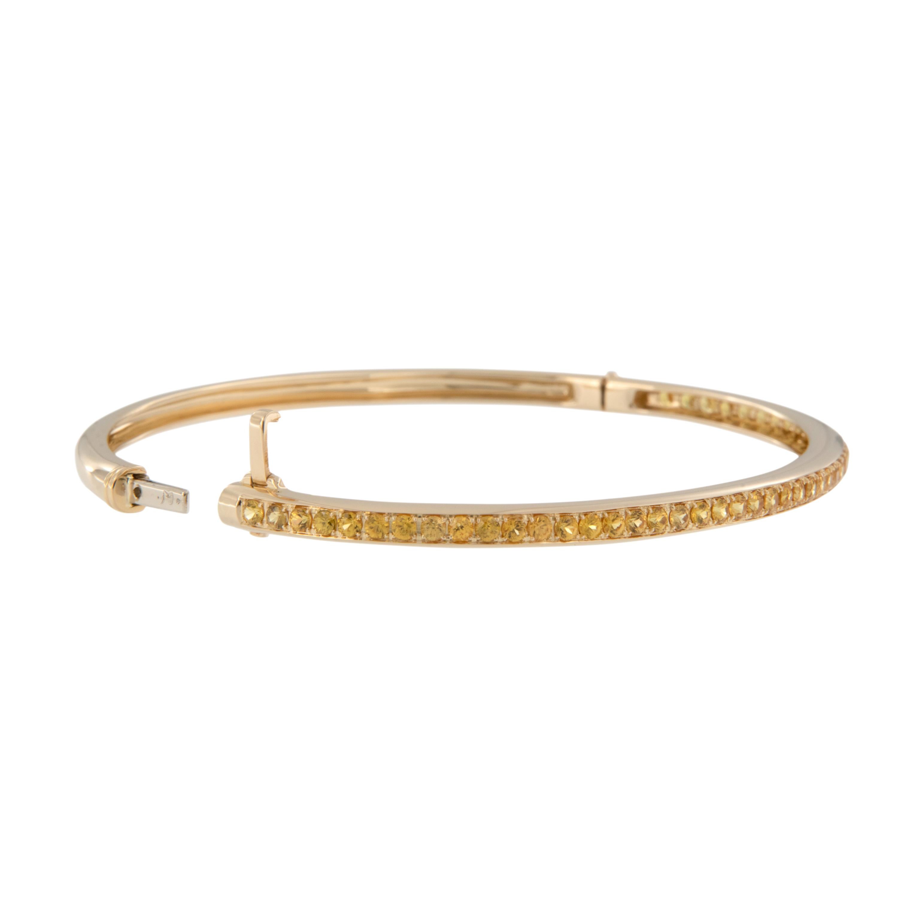 This bracelet is like wearing sunshine on your wrist! Classic oval design & shape sparkling with 1.69 Cttw of sunny yellow sapphires set in rich 18 karat yellow gold for a classic look by Suarez. Worn on its own or stacked with other bangles, this