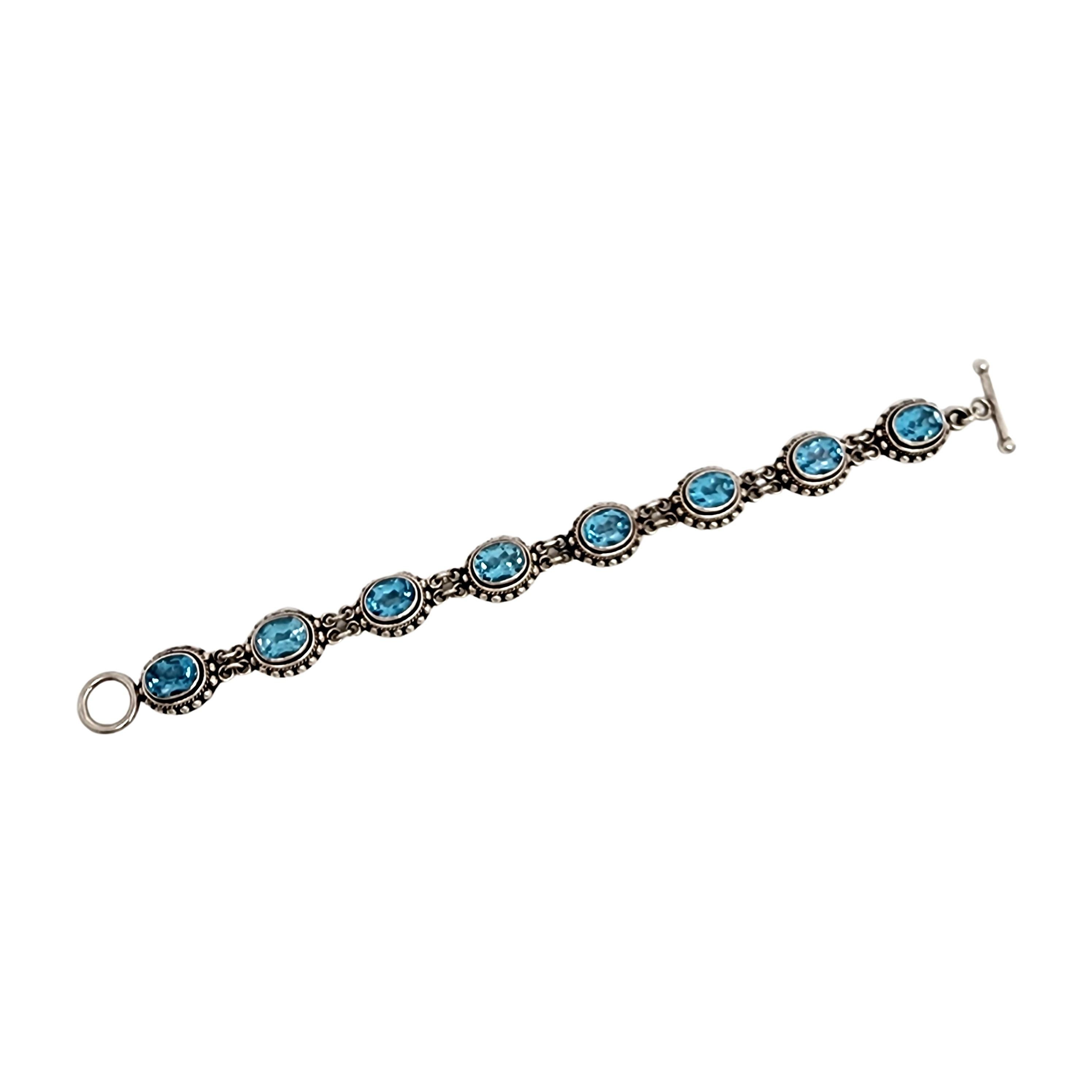 Sterling silver and blue topaz toggle bracelet and earrings set by Suarti.

Beautiful oval link bracelet and matching earrings  featuring bezel set blue topaz stones surrounded by rope and beaded designs. Bracelet features a toggle
