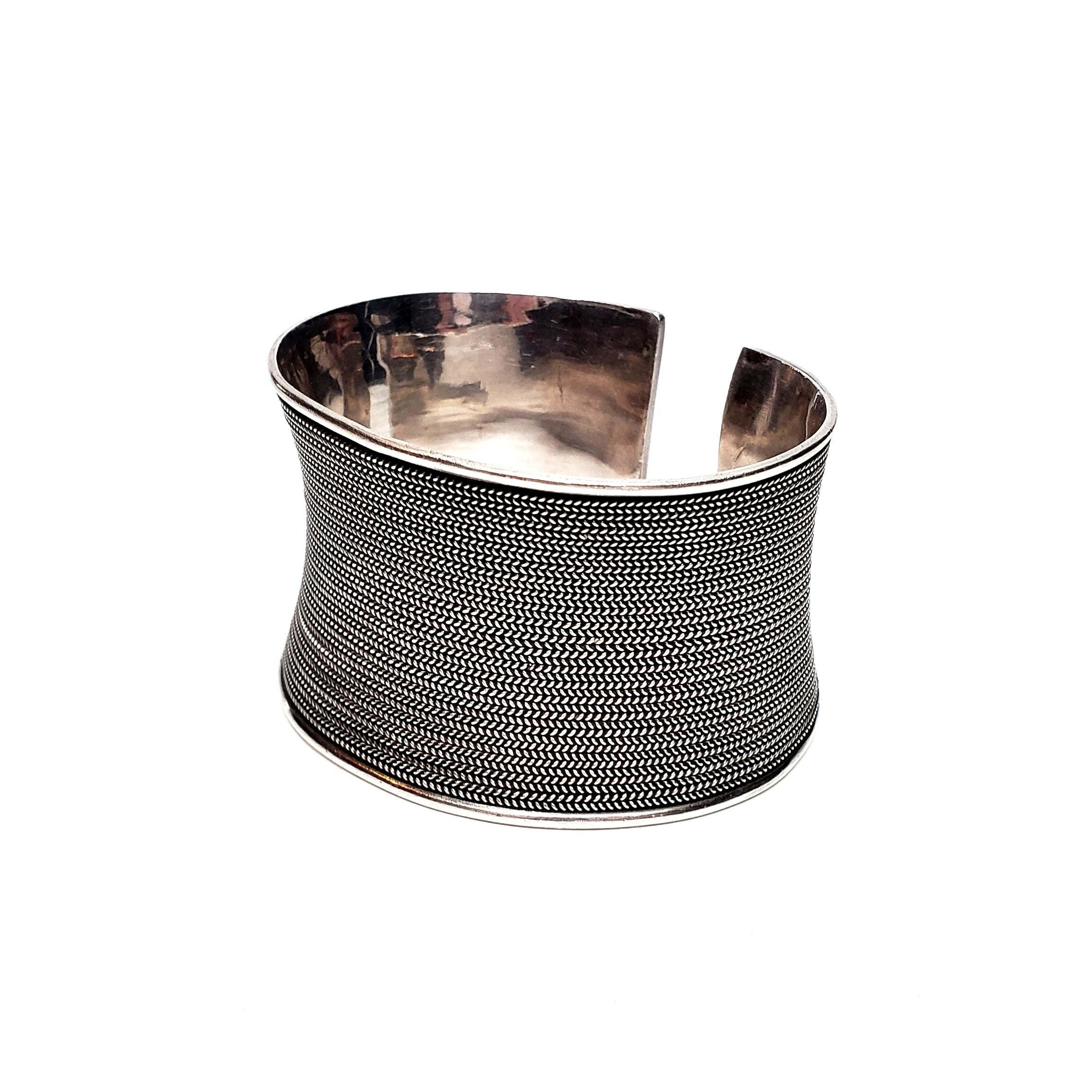 Sterling silver braided cuff by Suarti.

This handcrafted artisan piece features rows of rope twist design that give the overall look of braided silver. It is wide, but lightweight.

Measures approx 6