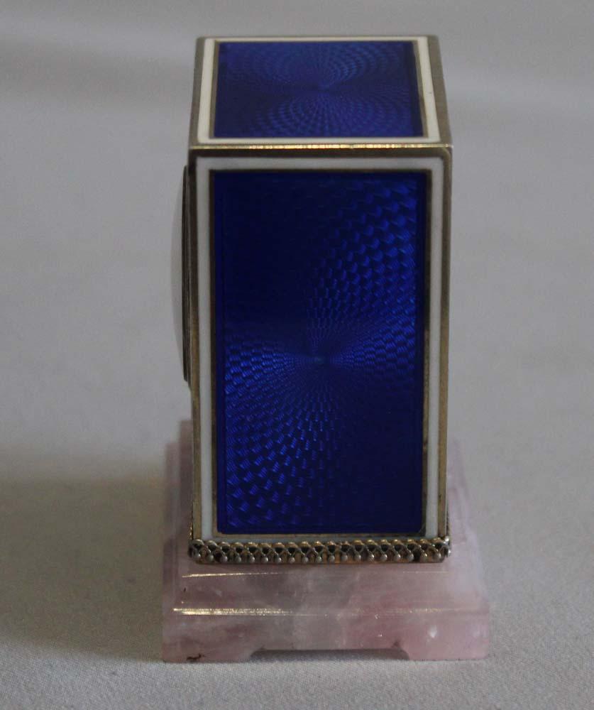 Sub miniature carriage clock in silver gilt, enamel and rose quartz. Fine quality case in perfect condition. The clock sits upon a shaped rose quartz base with a silver gilt Gothic frieze around the base of the gilt bronze case. The deep blue