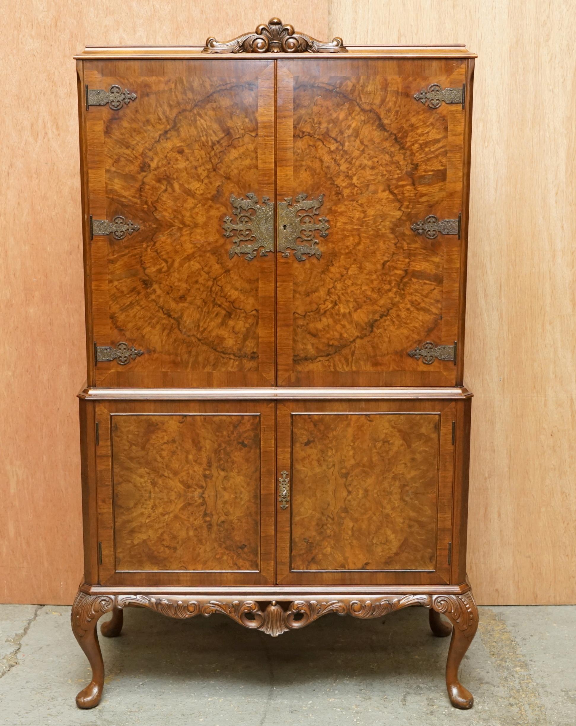 We are delighted to offer for sale this lovely antique circa 1920 Art deco Burr Walnut drinks cabinet with ornately carved cabriolet legs, mirrored back and internal lights 

A good looking and decorative piece, the timber to the front top doors