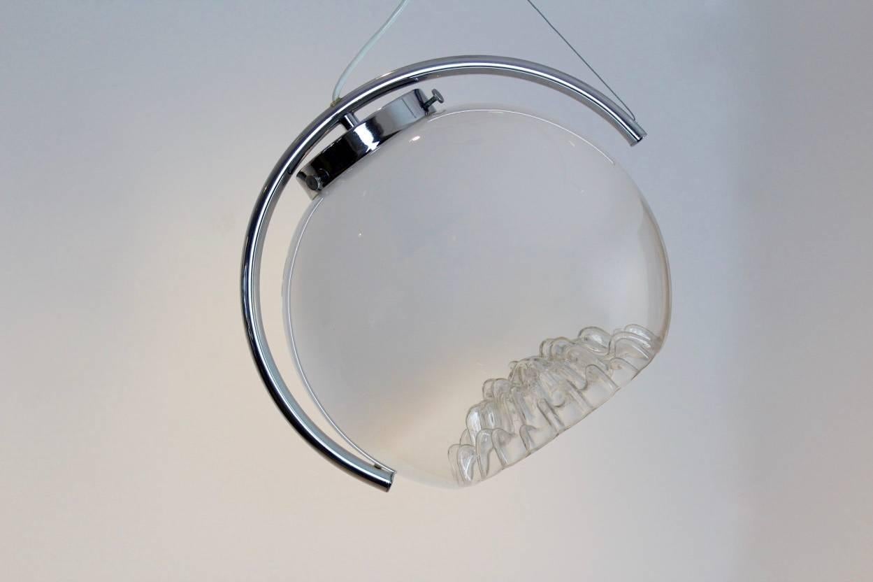 Magnifique pendentif réalisé par A.V.I. Mazzega avec une magnifique coupe caractéristique en verre semi-décapé de Murano sur une superbe base lunaire chromée avec trois positions réglables pour focaliser la lumière. Fabriqué au début des années