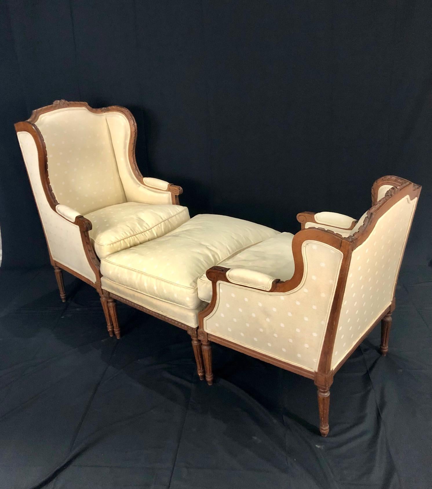 A French Louis XVI style walnut Duchesse Brisée with two bergère chairs and their ottoman from the late 19th century and newer upholstery. This French chaise lounge set features three sections consisting of two bergères of slightly different