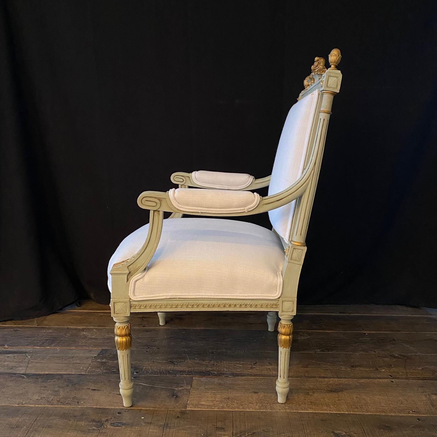 Elegant pair of French Louis XVI neoclassical armchairs having stunning Silhouette with carved painted wooden frame and new high quality British cotton/linen neutral fabric upholstery. The chairs have a square back rest and seat carved with