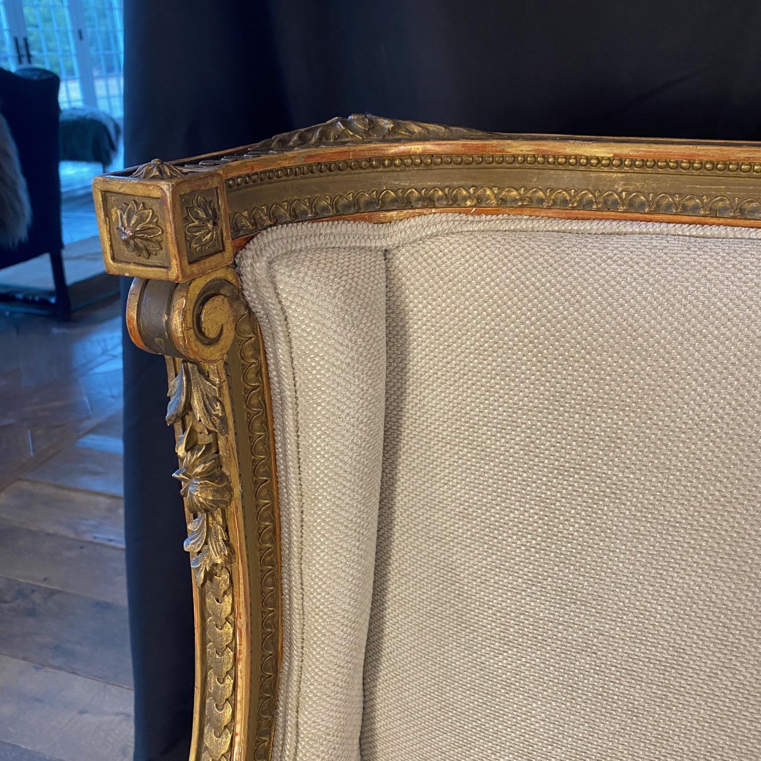 Sublime pareja de sillones franceses restaurados para él y para ella tallados en nogal dorado Luis XVI en venta