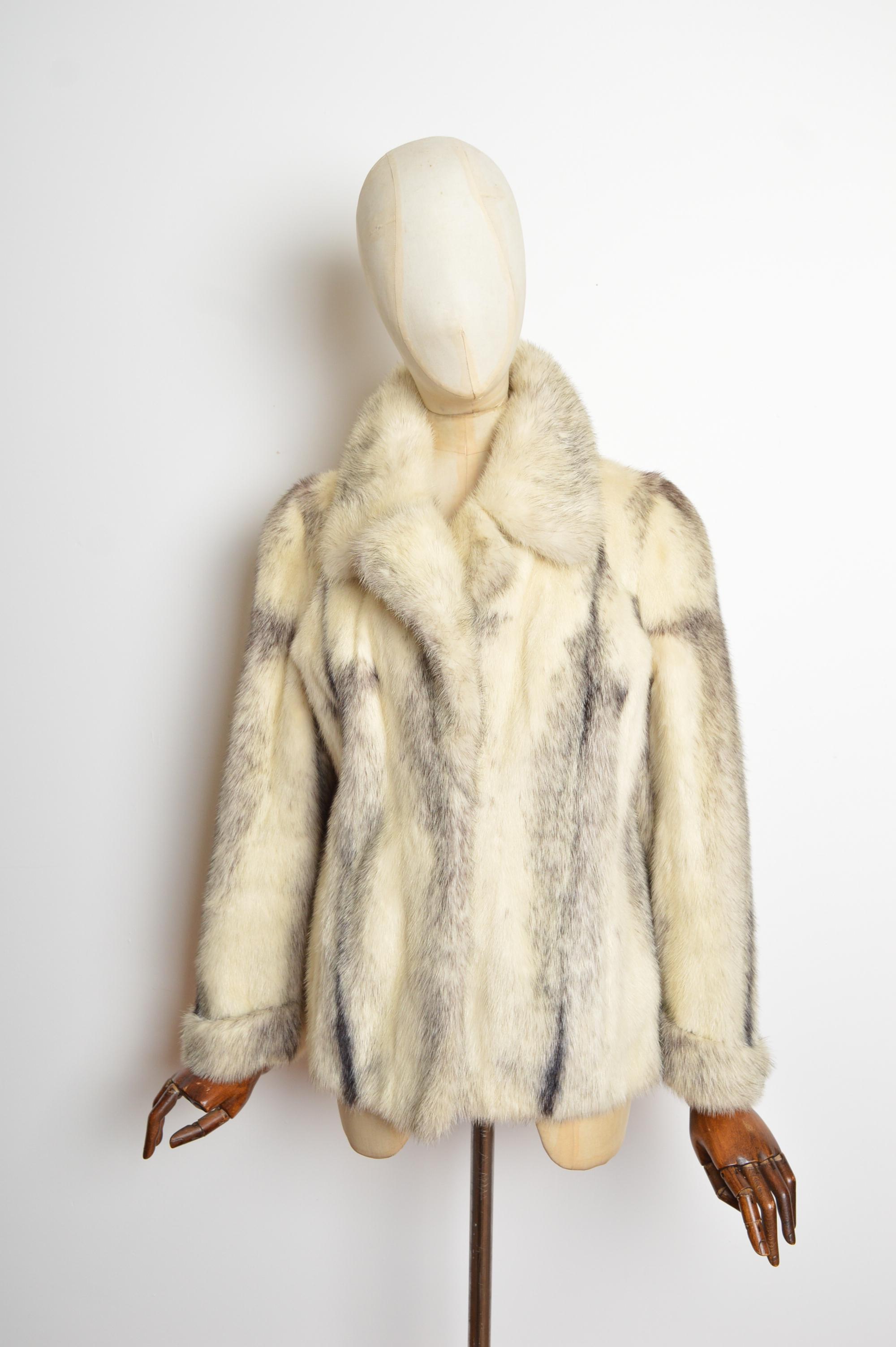 An Impeccable vintage Mink fur coat. Crafted from Plush black & ivory white speckled pelts, featuring a simple collar, pleated wrist cuffs and pockets at the hips. The jacket closes via farrier hooks down the centre and is fully lined in a black