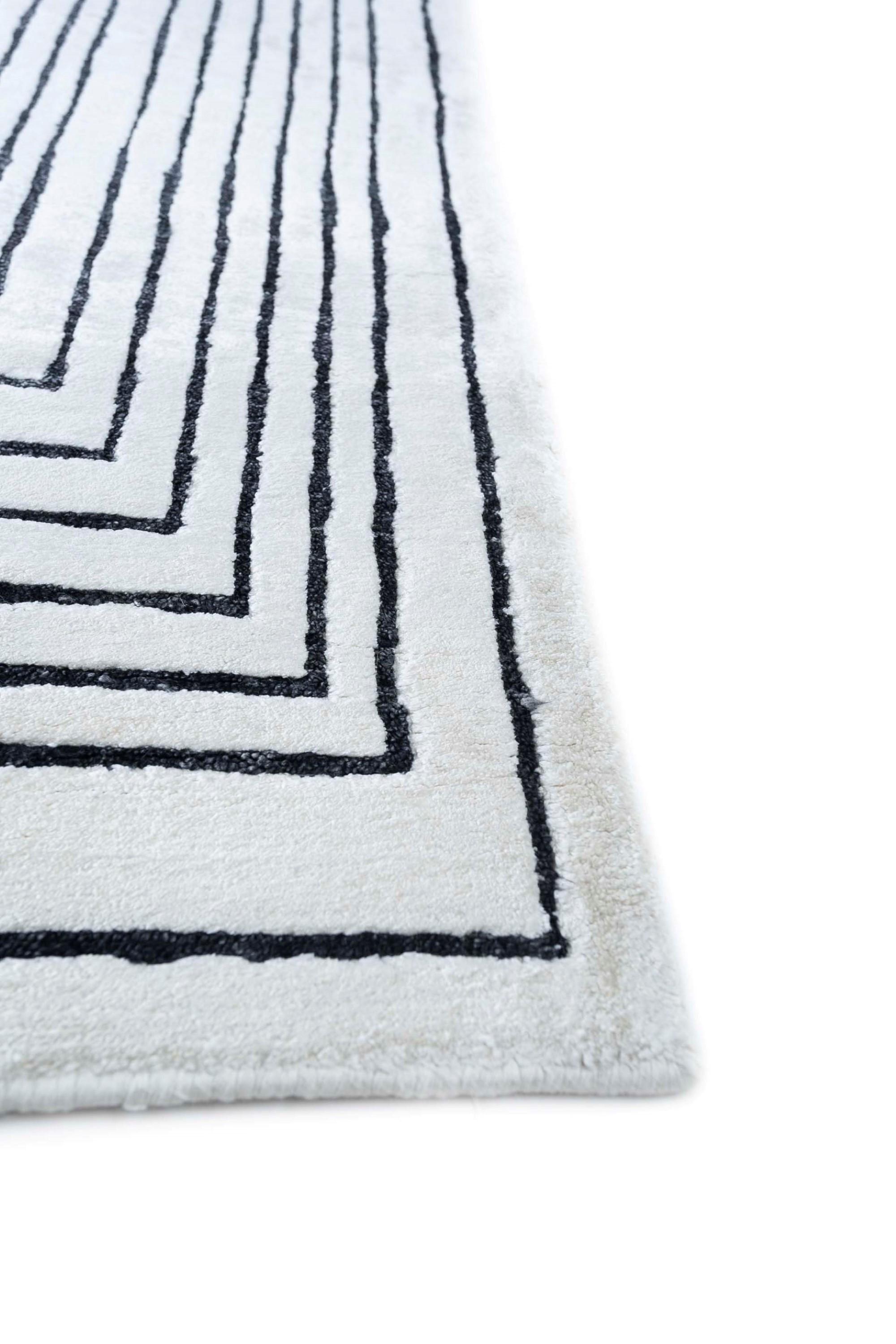 What if your rug could be a mood-lifter for your space? Introducing this hand-knotted marvel . With a soothing tone-on-tone palette, this modern rug, handcrafted with care, instantly uplifts the mood of any room. The white ground and ebony border