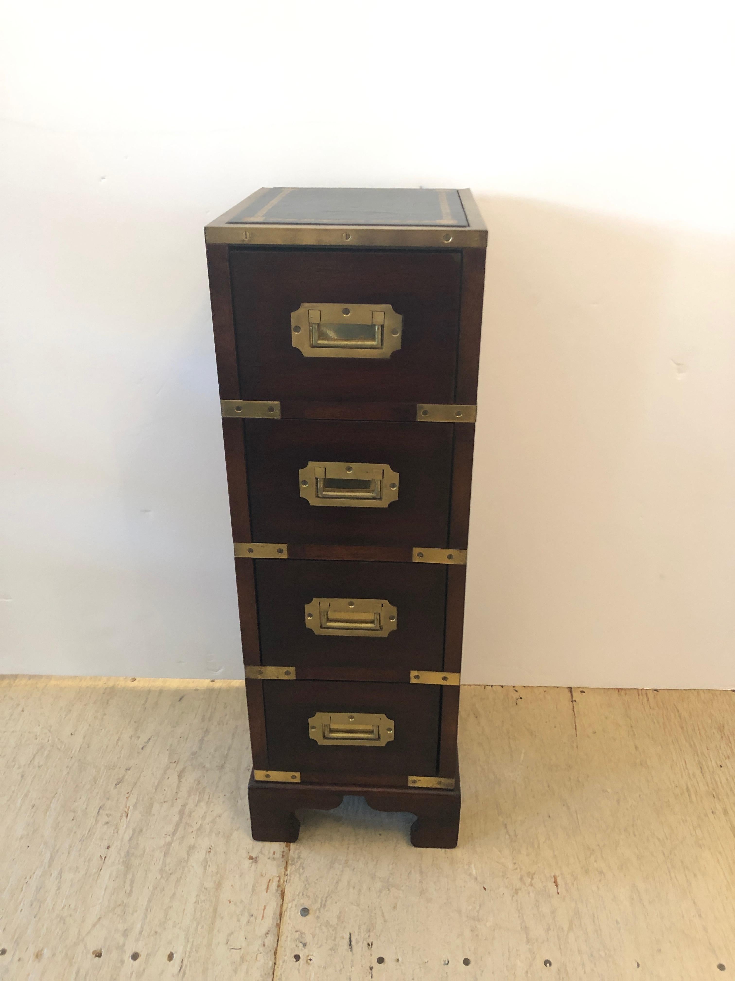 An amazing elegant tall narrow mahogany Campaign chest or side table having 4 stacked drawers with Classic recessed brass hardware and details topped off with a handsome black and gold tooled leather top framed by a brass gallery. A rare jewel in
