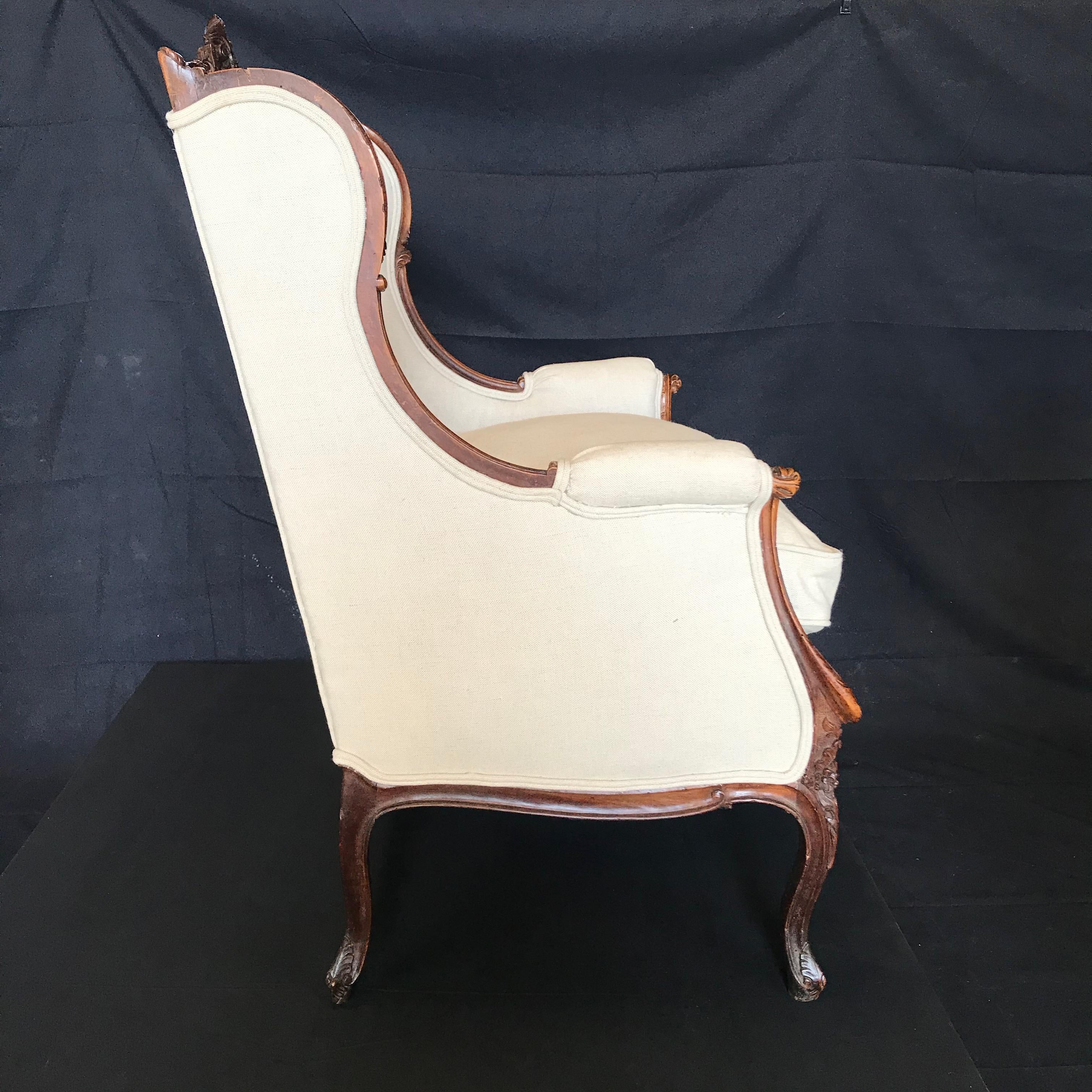 Classic and uber pretty mid-19th century French Louis XV carved armchair in dark walnut. Antique, yet super comfortable, this early armchair has an intricately carved back, arms legs and apron, with scrolled acanthus leaves amidst blossoming