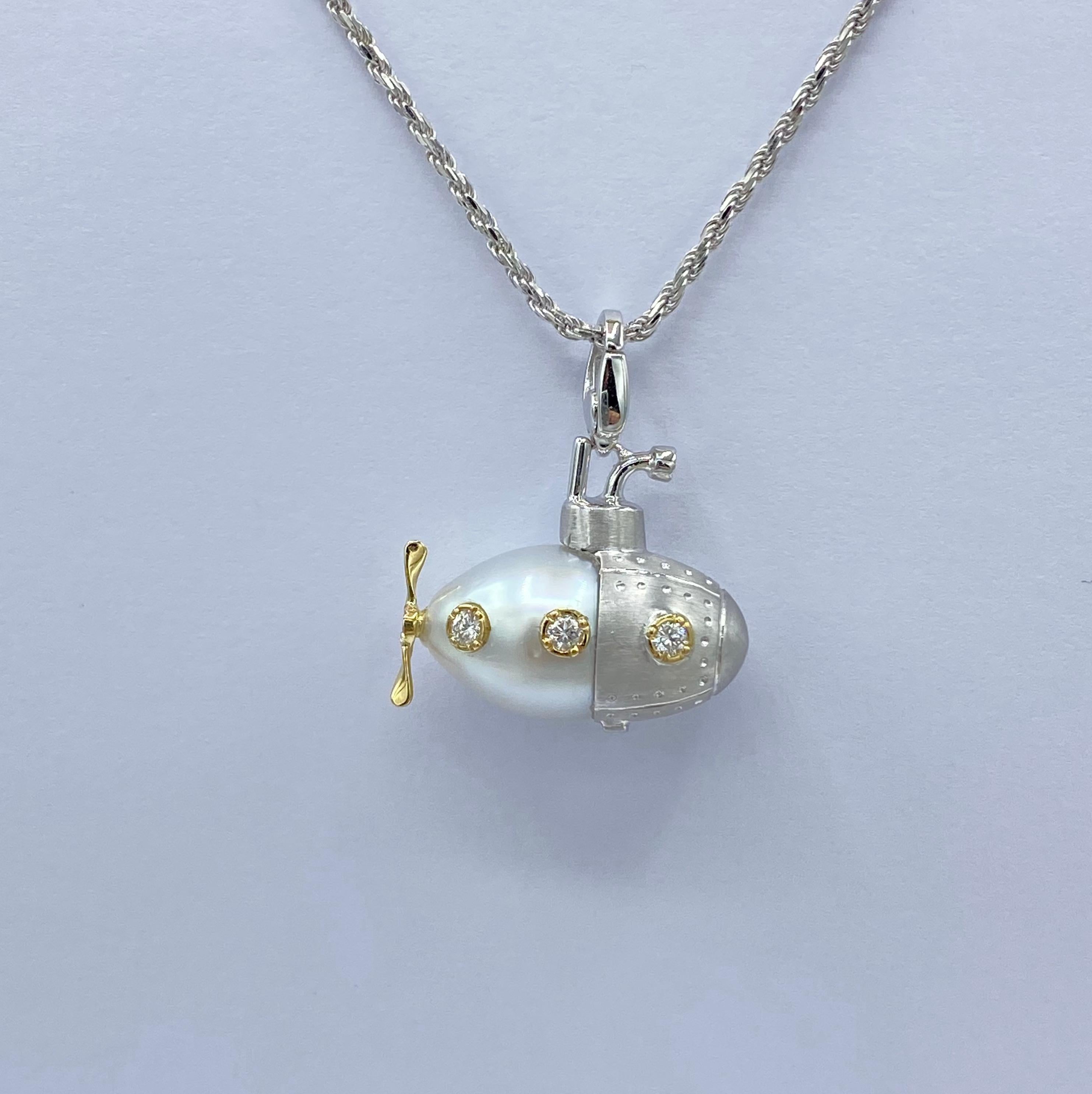 I created a submarine pendant using a slightly oval Australian pearl and lengthening it and defining its shape with white gold. The finish is satin.
The yellow gold portholes set a white diamond for each.

A blue sapphire is set on the periscope.