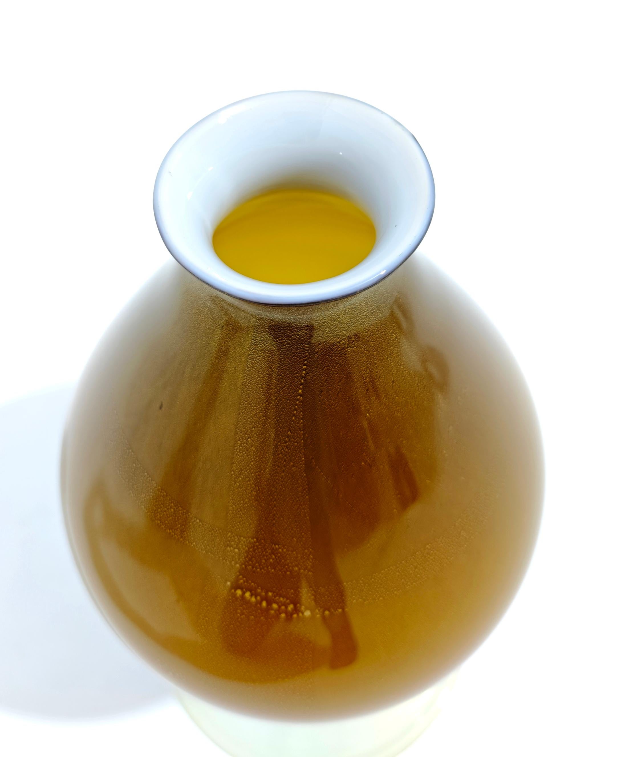Vase fabriqué à Murano, Italie, vers 1960/70. Verre de Sommerso avec inclusions d'or. Dans le ton de la couleur moutarde. Corps ovale, col circulaire bas légèrement évasé. Base circulaire de couleur claire. Veuillez regarder attentivement la vidéo