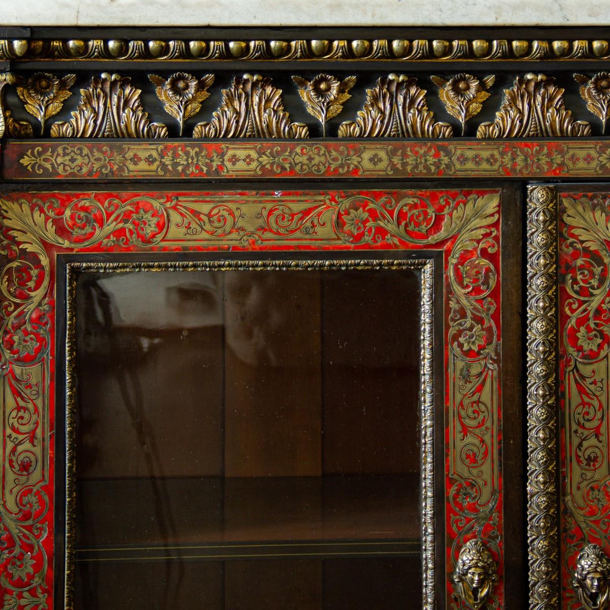 A 19th century French boulle cabinet with ormolu mounts, and finely worked inlay in engraved brass on red under laid tortoiseshell. The two doors are glazed revealing shelving.

Elaborately decorated with floral and foliage decoration, punctuated