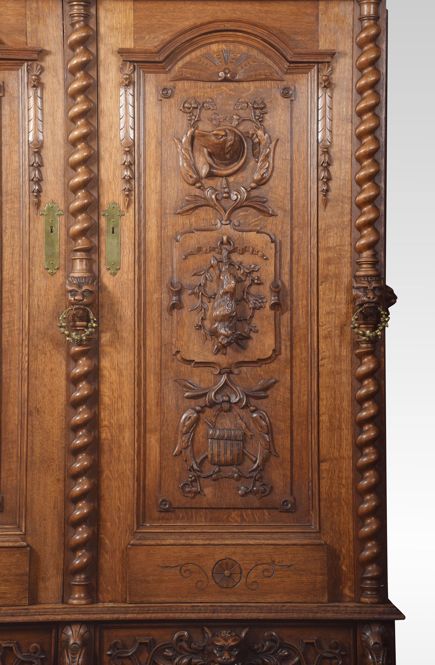 Substantial 19th century oak cabinet, The projecting moulded cornice with egg and dart moulding over a pair of panelled doors with overall carved relief of hanging game, hounds, lion masks and further geometric detail. Opening to reveal four