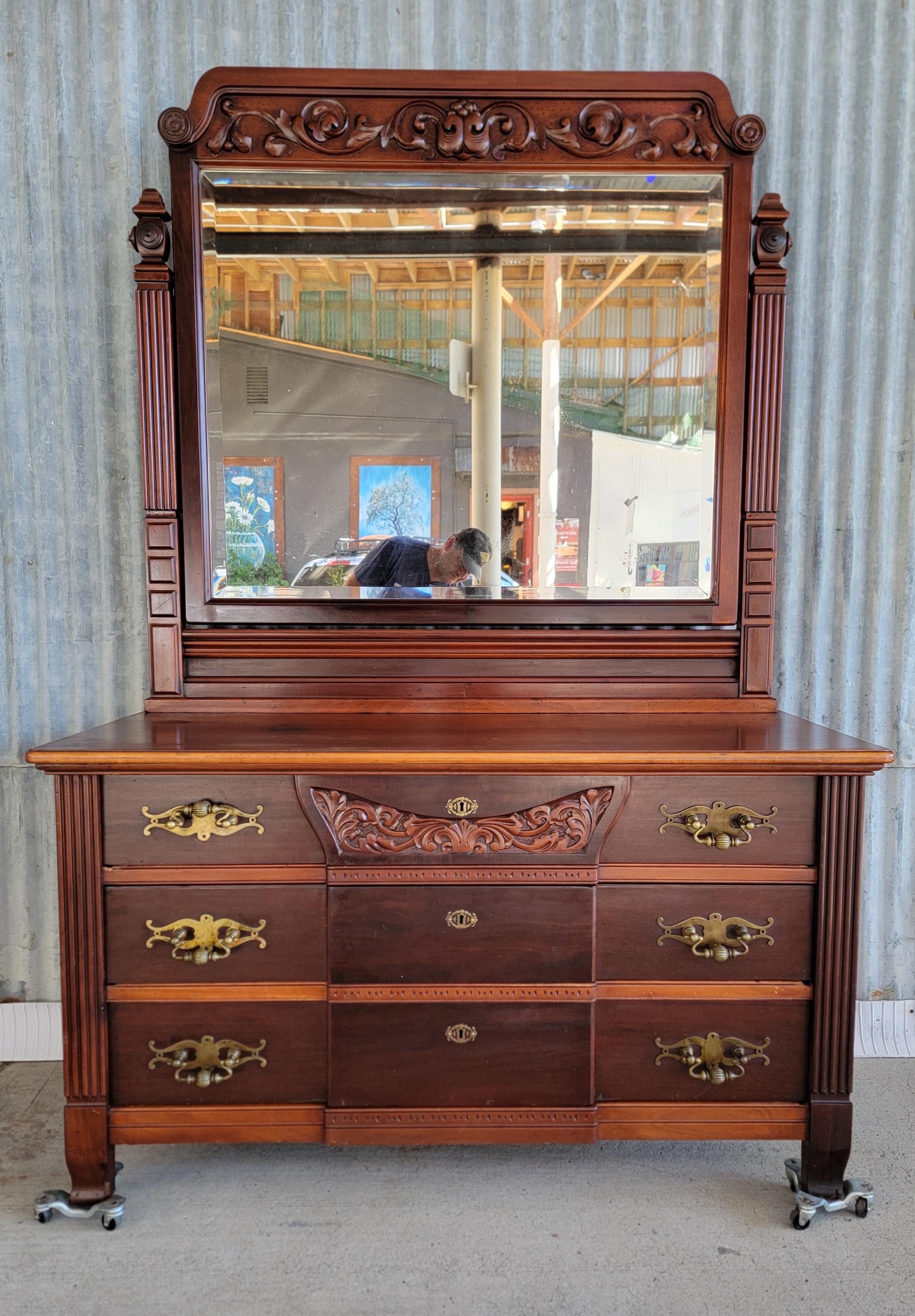 A substantial, over-sized American Victorian dresser with large beveled mirror. Beautiful ribbon cut and cross cut mahogany construction. Heavy and large solid brass drawer pulls. Circa. 1870-1880.

79 inches high.
54 inches wide.
24.25 inches deep.