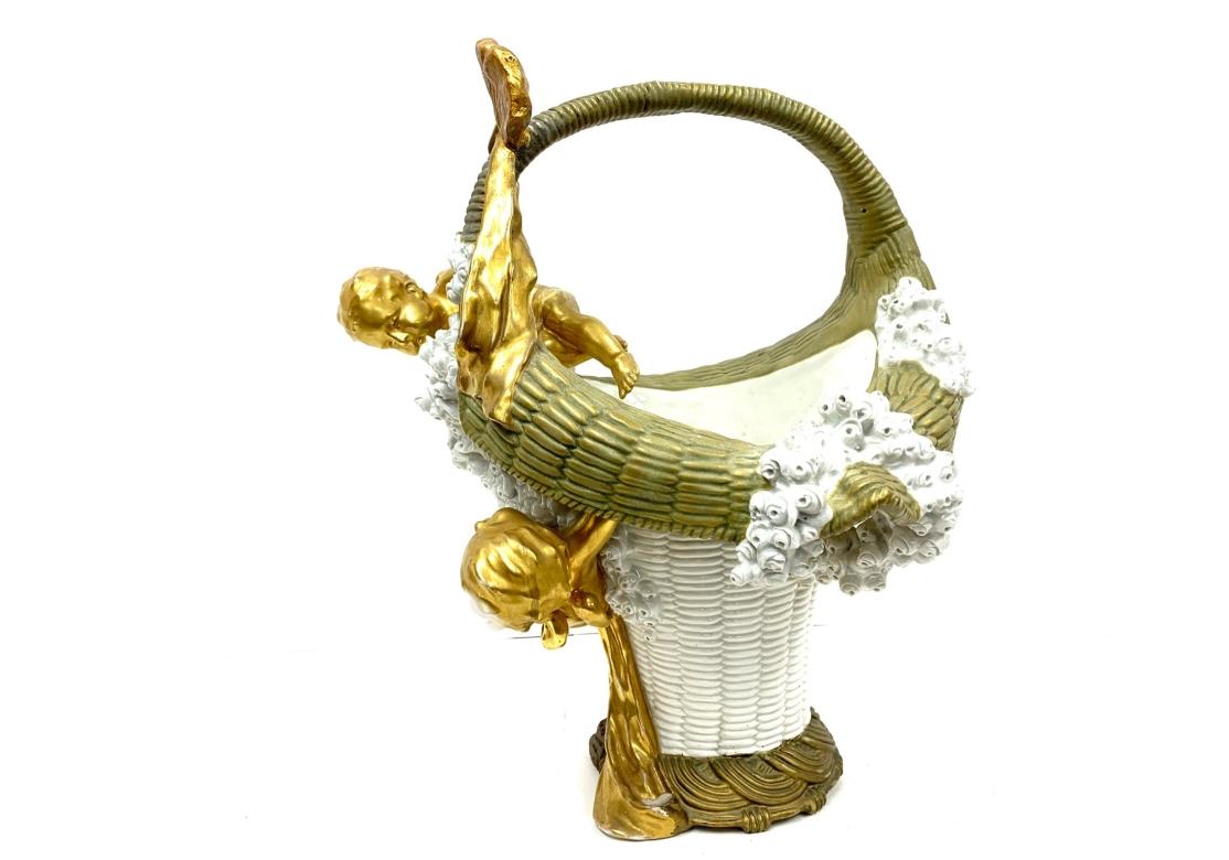A large white porcelain enamel handled basket with faux woven design, decorated with two playful cherubs among cascading rosettes. The basket is decorated with an olive rim and fluted handle.
Late 19th century stamped 