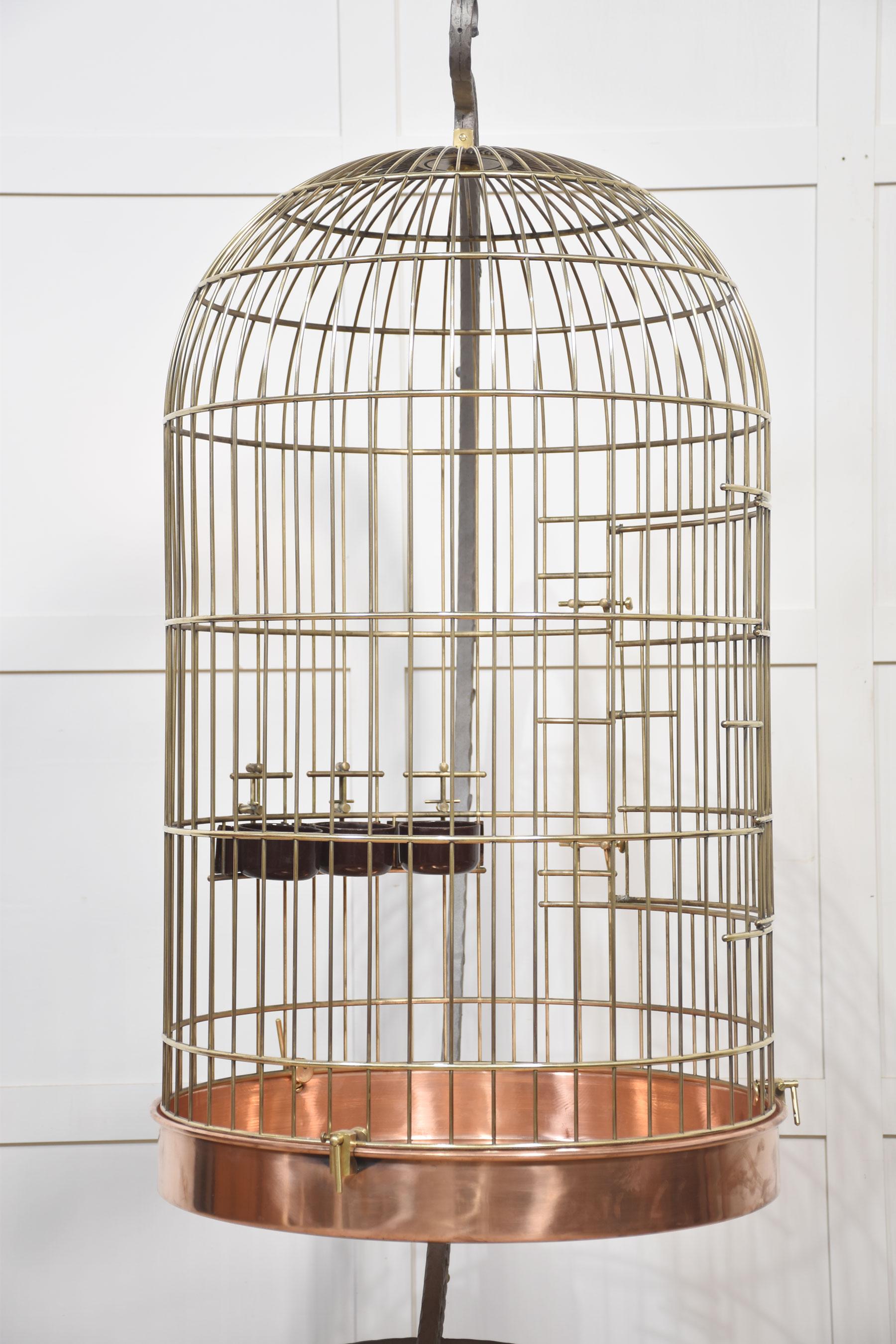 Gabbia per uccelli o voliera in ottone, con una gabbia a forma di cupola con fondo in rame sostenuta da un telaio in ferro battuto con decorazione a volute.
Dimensioni
Altezza 74 pollici
Larghezza 32 pollici
Profondità 41 pollici

Dimensioni della