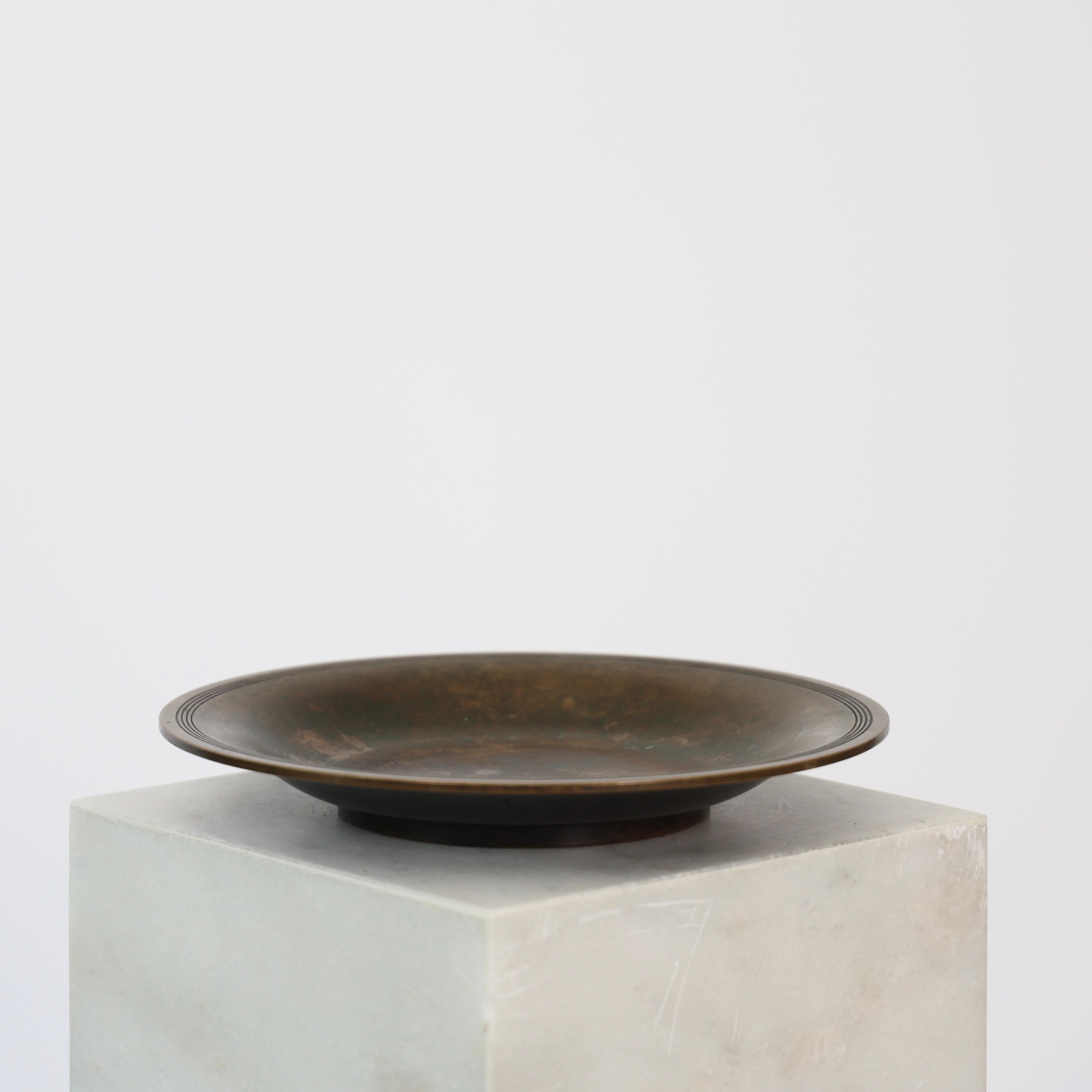 Impressive Bronze Bowl made by Just Andersen in the 1930s. 

* Round bowl in full bronze with circular lines on the rim
* Designer: Just Andersen
* Model: B2148
* Year: 1937
* Condition: Good vintage condition. Makers engravings intact. Fine patina
