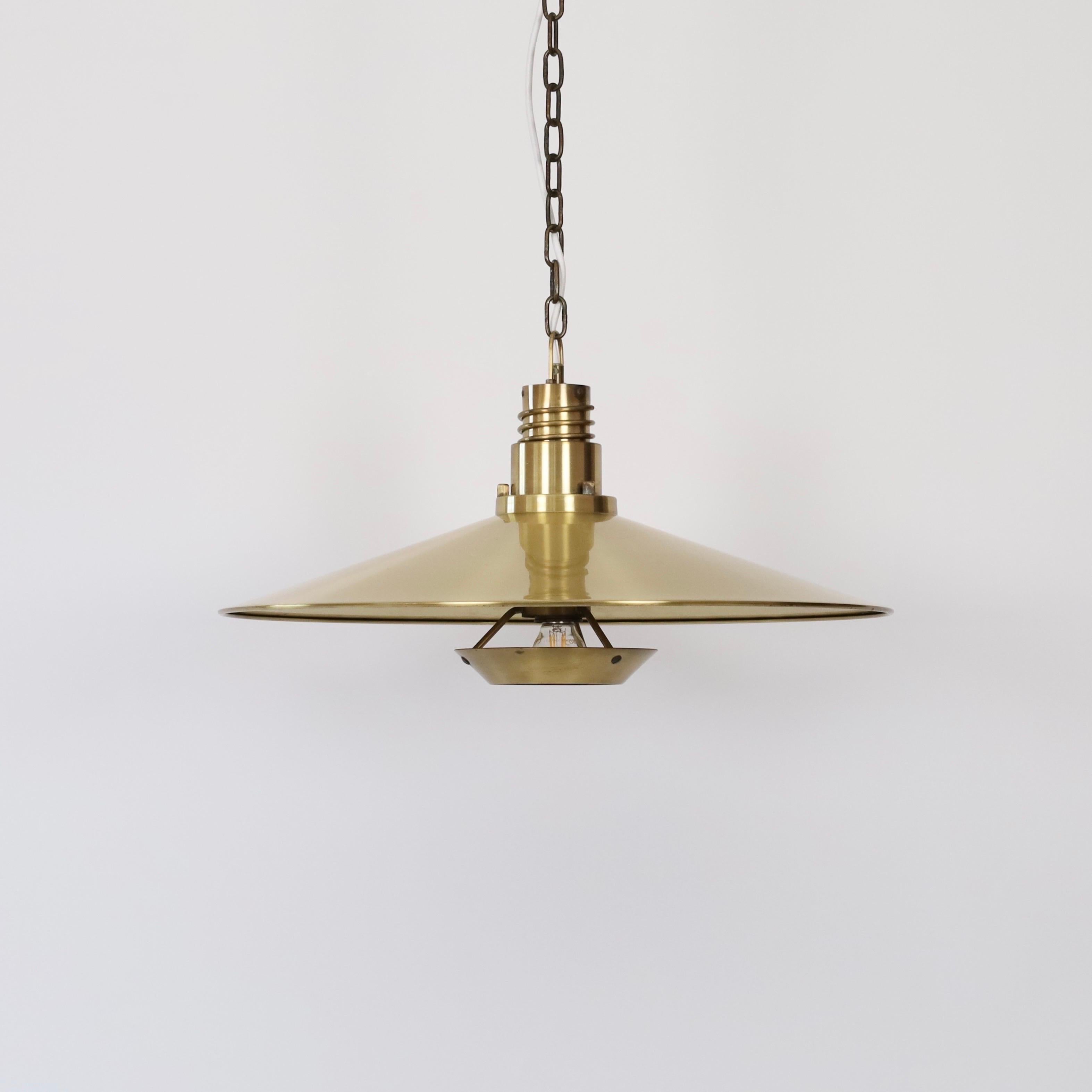A brass pendant light made by Fog & Mørup in the 1960s. Substantial and impressive.

* A brass pendant light with adjustable positioning of the bulb and blinder
* Designer: Unknown
* Producer: Fog & Mørup Denmark
* Year: 1960s
* Condition: Good