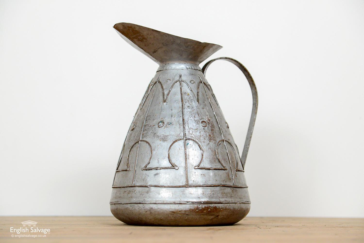 Substantial metal pitcher jug with simple Art Nouveau style decoration applied in moulded wire. It is naively made and has a weathered appearance with small areas of rust/discoloration. Measurements given below are inclusive of handle and spout.