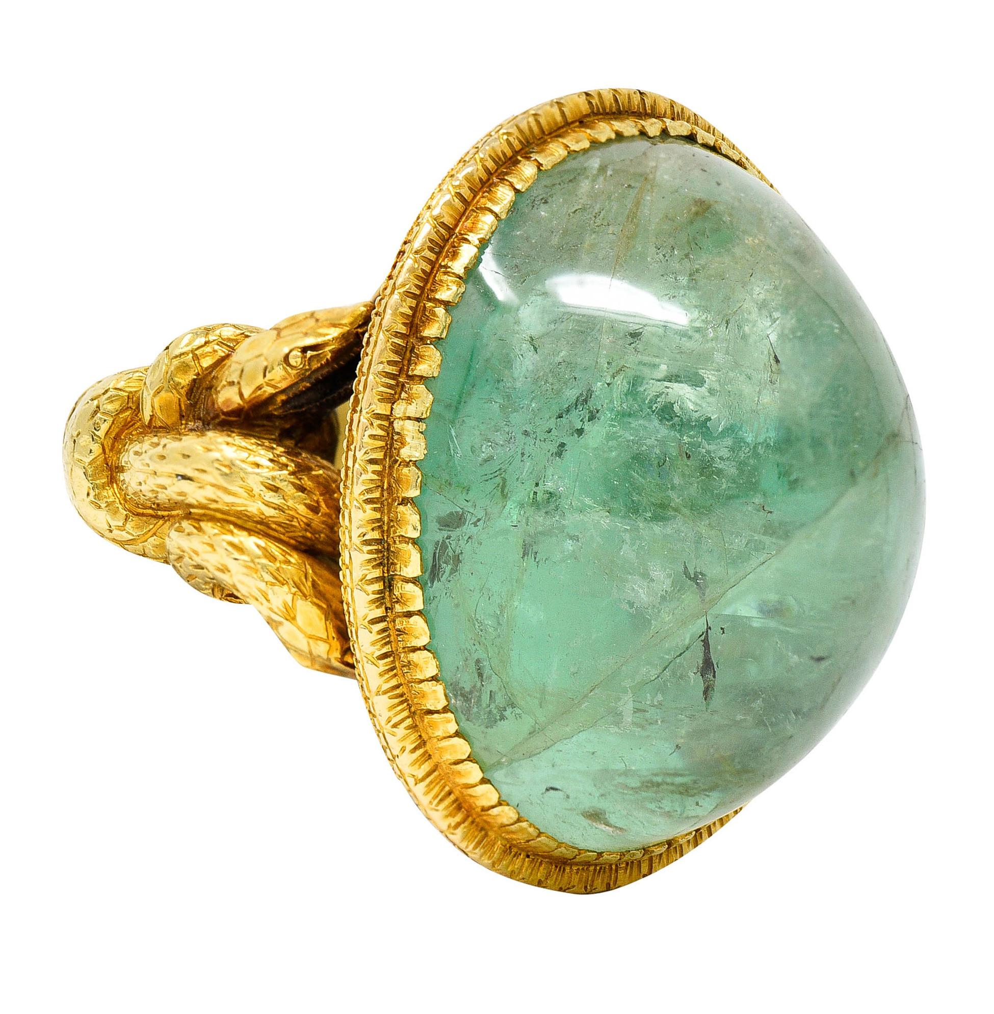 Centering a highly domed oval emerald cabochon weighing approximately 16.00 carats

Medium light green with bluish undertones and translucent with natural inclusions

Set in a textured gold surround with a fanciful scalloped edge

Shank and