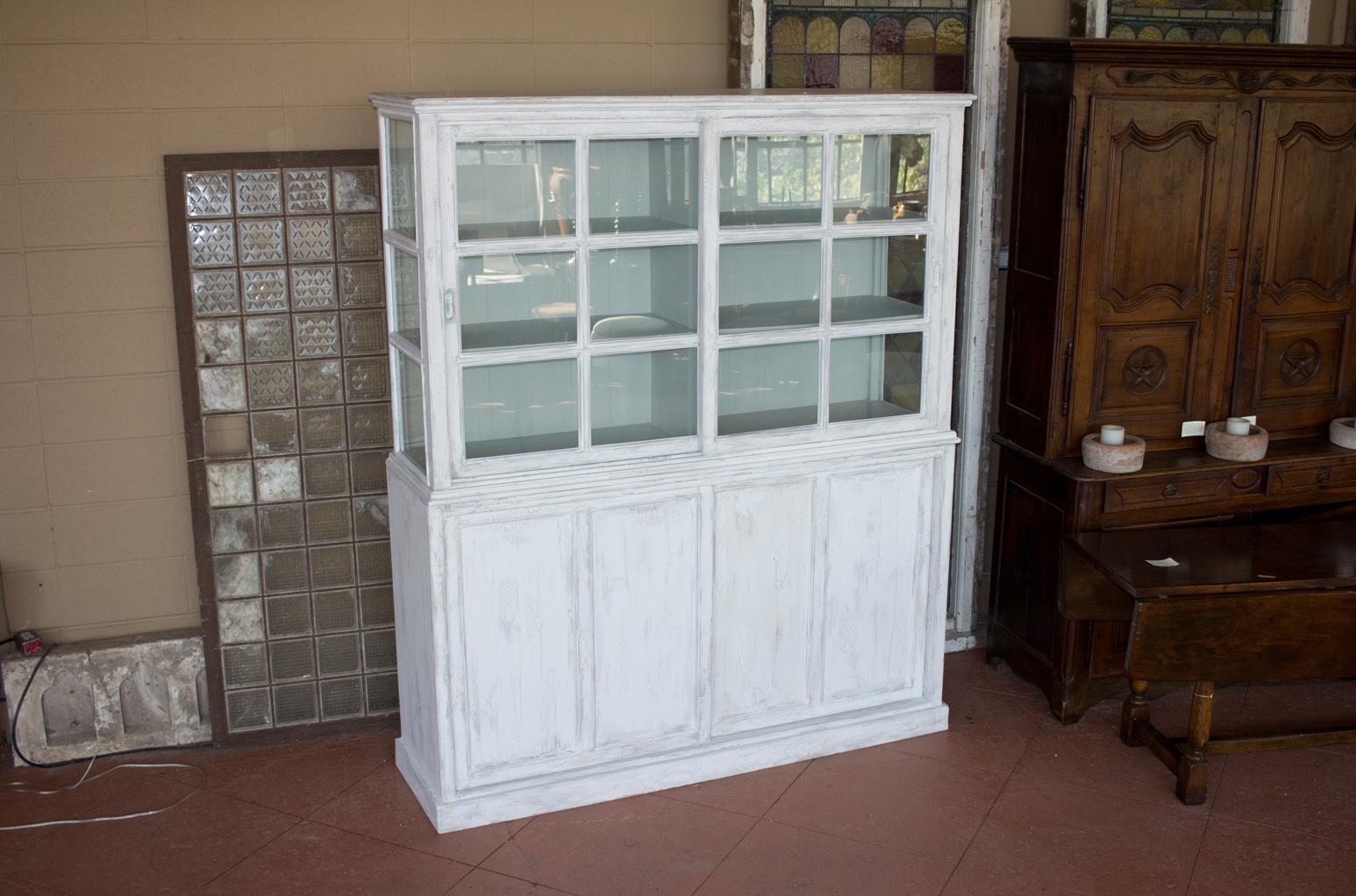 Substantial painted bookcase or cabinet. The top is unusual as it’s glazed both on the front and the sides, very attractive! The base of the cabinet is spacious with plenty of storage space. Both top and bottom have sliding doors.

Early 20th